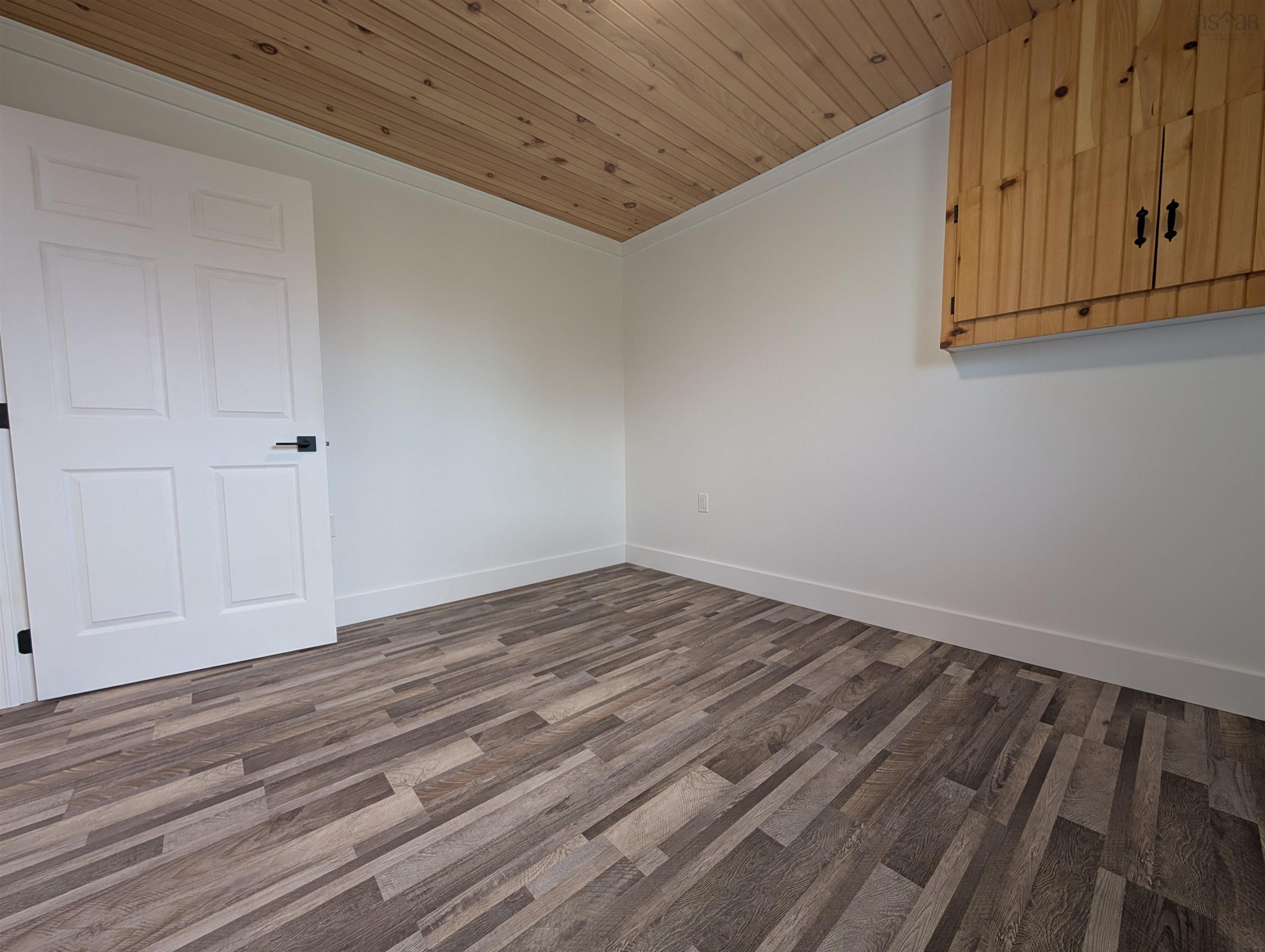 Spare room featuring wood ceiling, ornamental molding, and wood finished floors