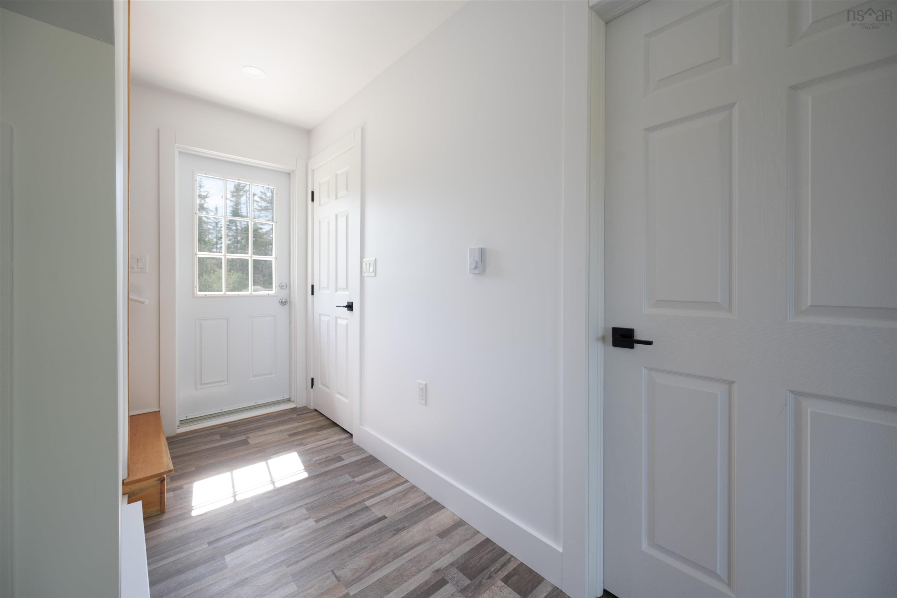 Doorway to outside with light wood-type flooring and baseboards