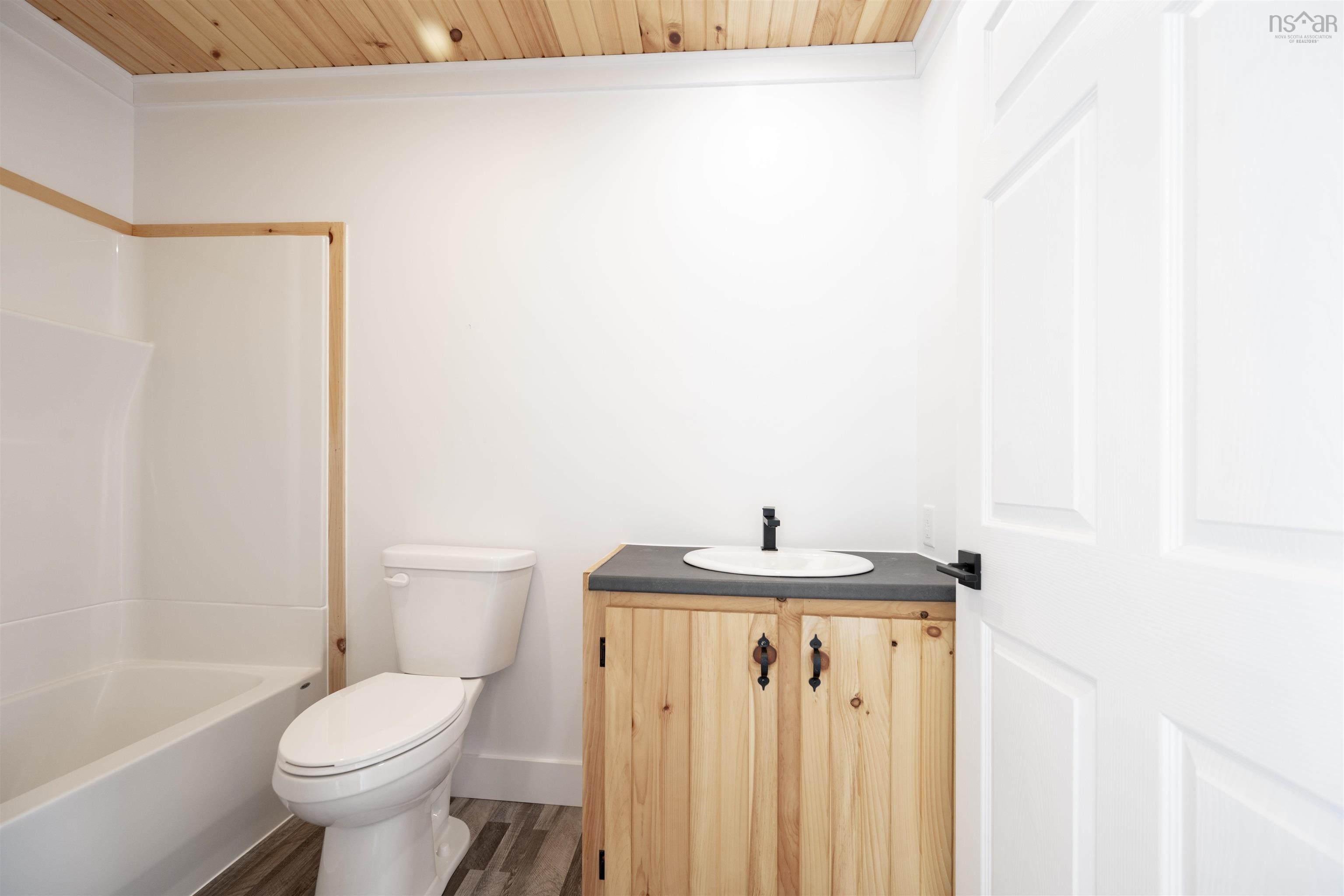 Bathroom with wood finished floors, vanity, wood ceiling, tub / shower combination, and crown molding
