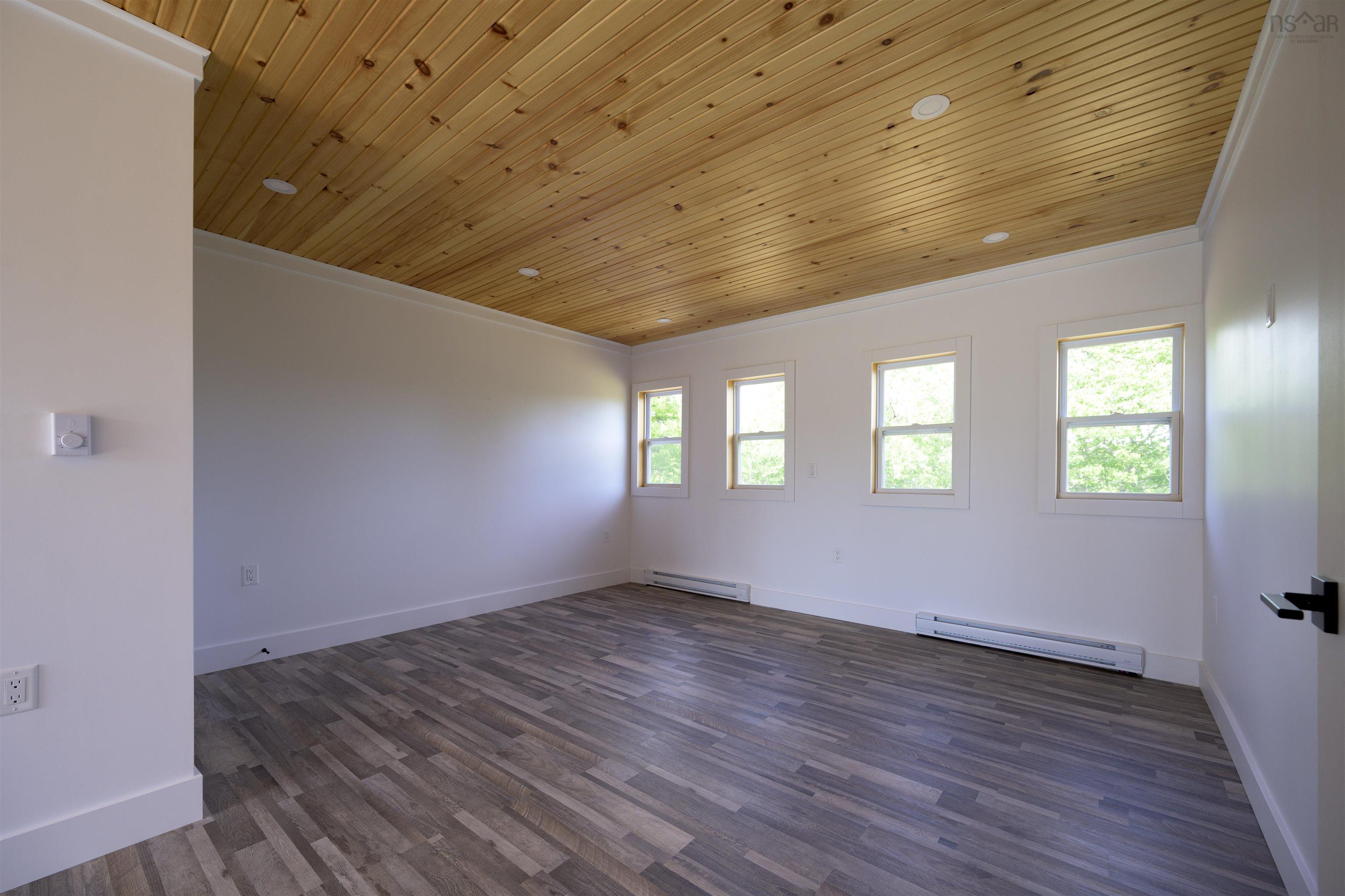 Spare room featuring wood ceiling, dark wood-style floors, ornamental molding, and baseboard heating