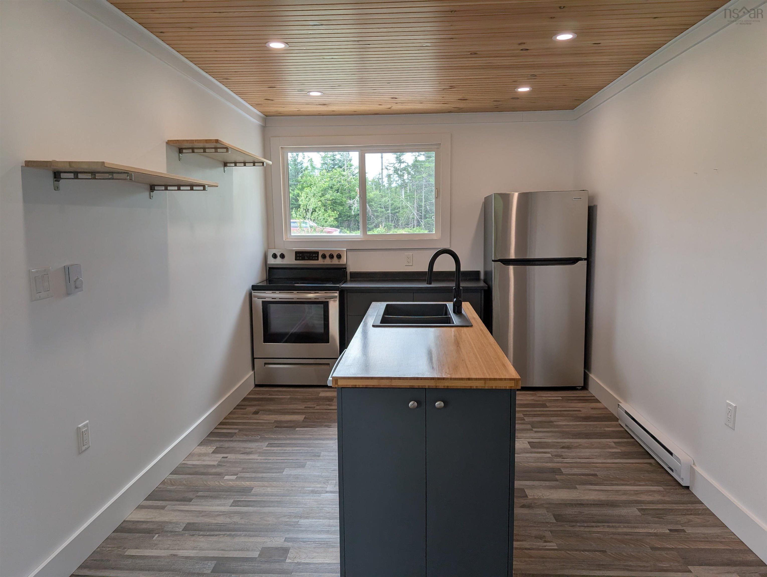 Kitchen featuring stainless steel appliances, ornamental molding, wood ceiling, baseboard heating, and dark wood-type flooring