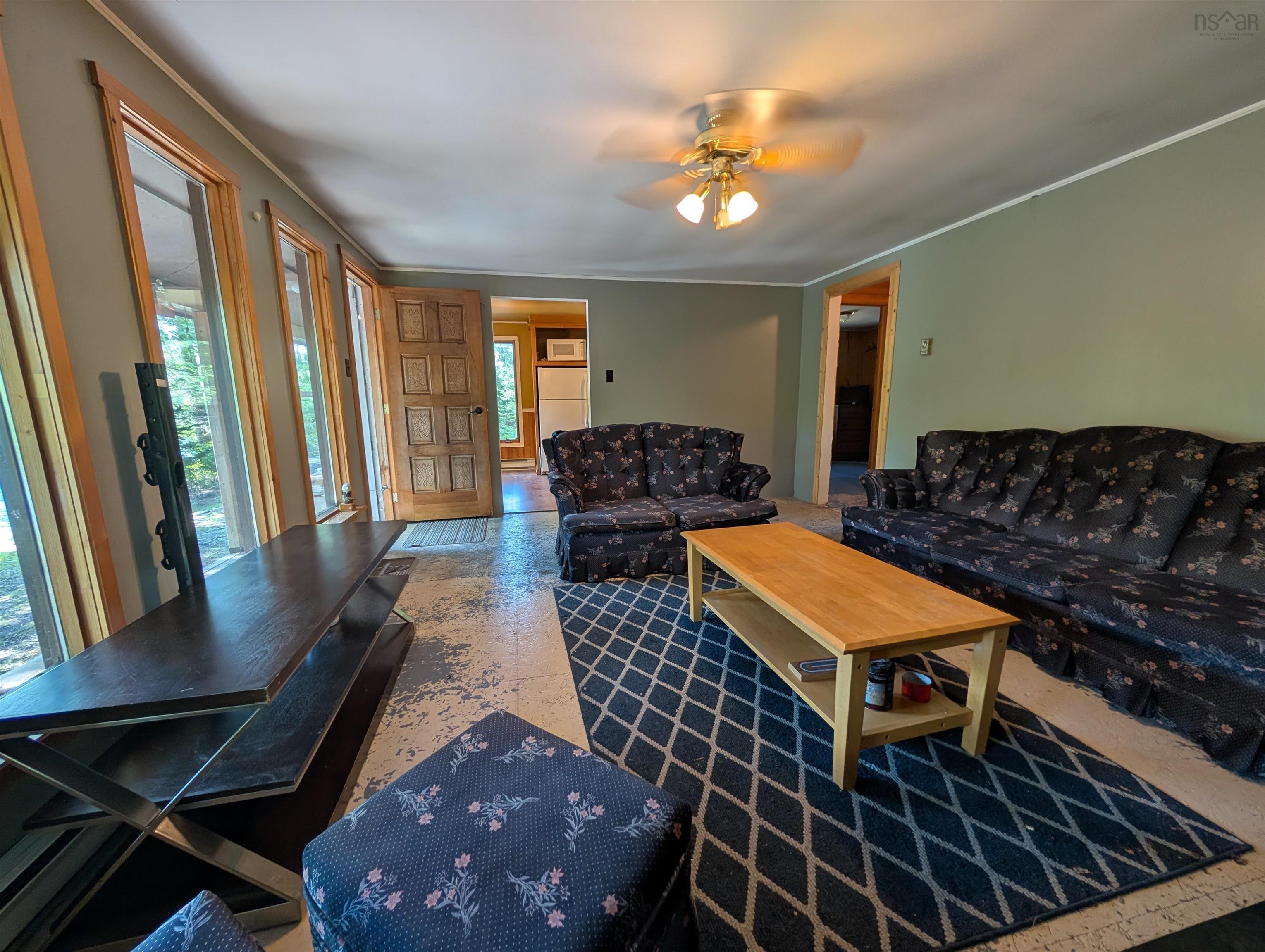 Living room featuring crown molding and a ceiling fan