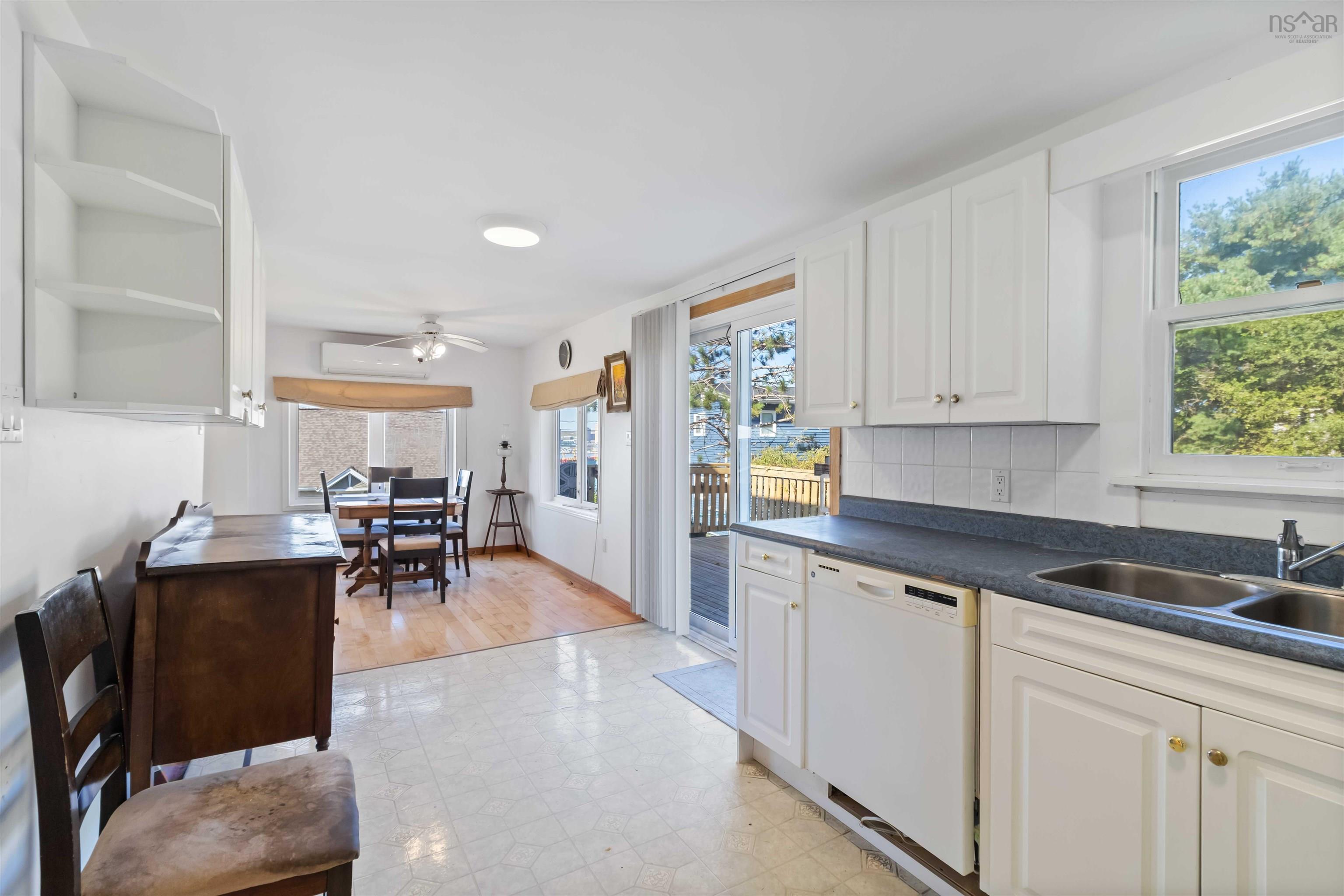 Kitchen with white cabinets, light flooring, dark countertops
