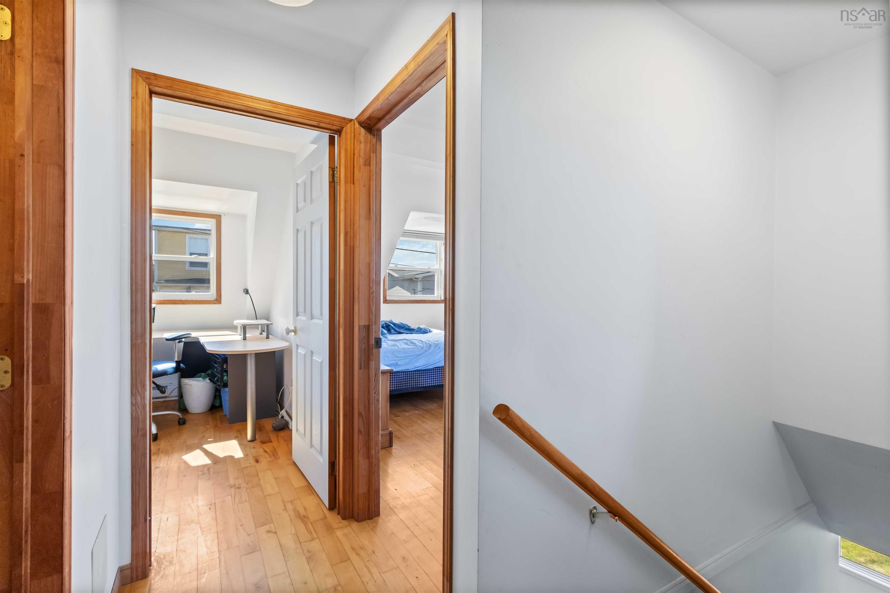 Hall with an upstairs landing and light wood-style flooring
