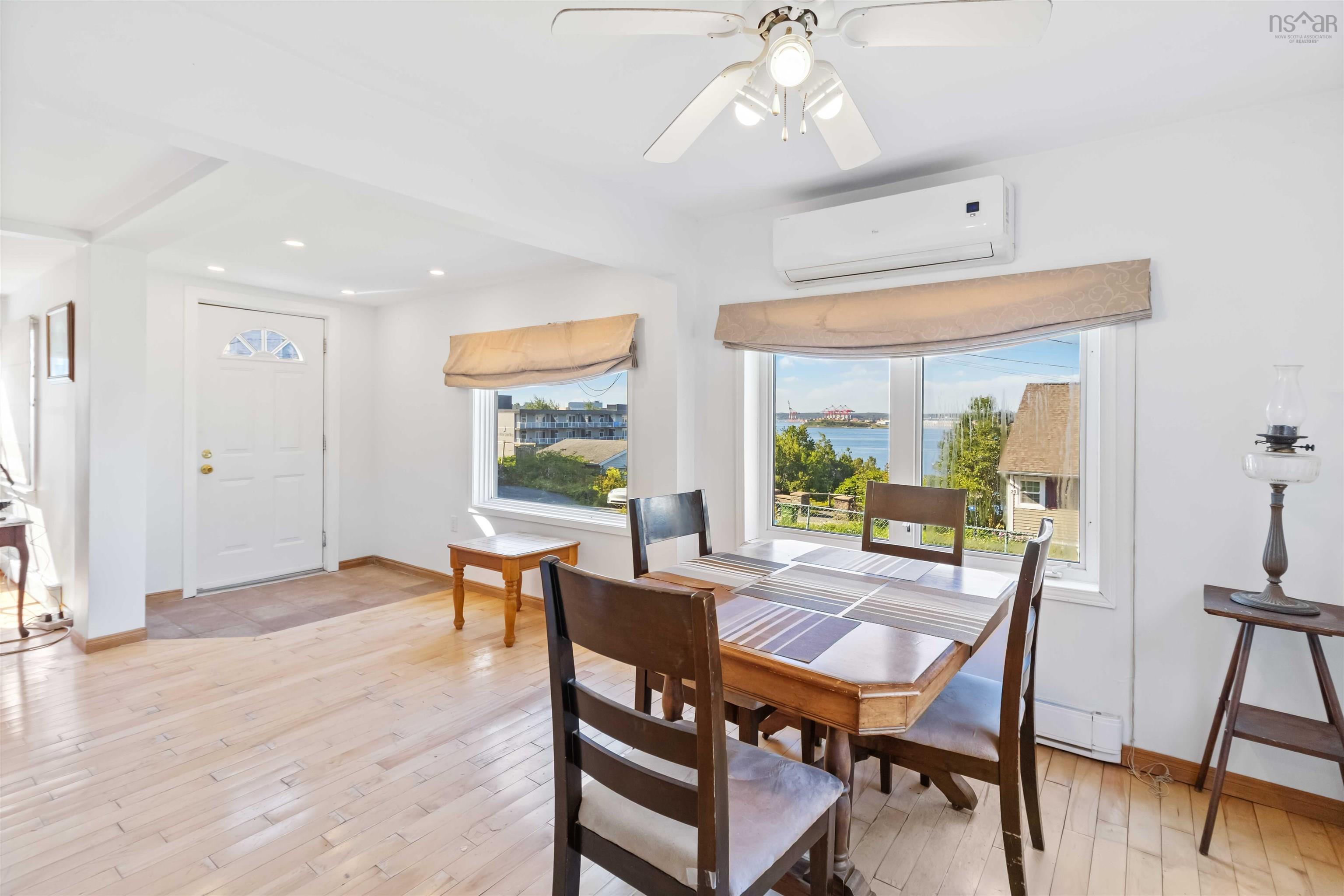 Dining area featuring a water view, healthy amount of natural light, light wood finished floors, a wall mounted Heat Pump, and recessed lighting
