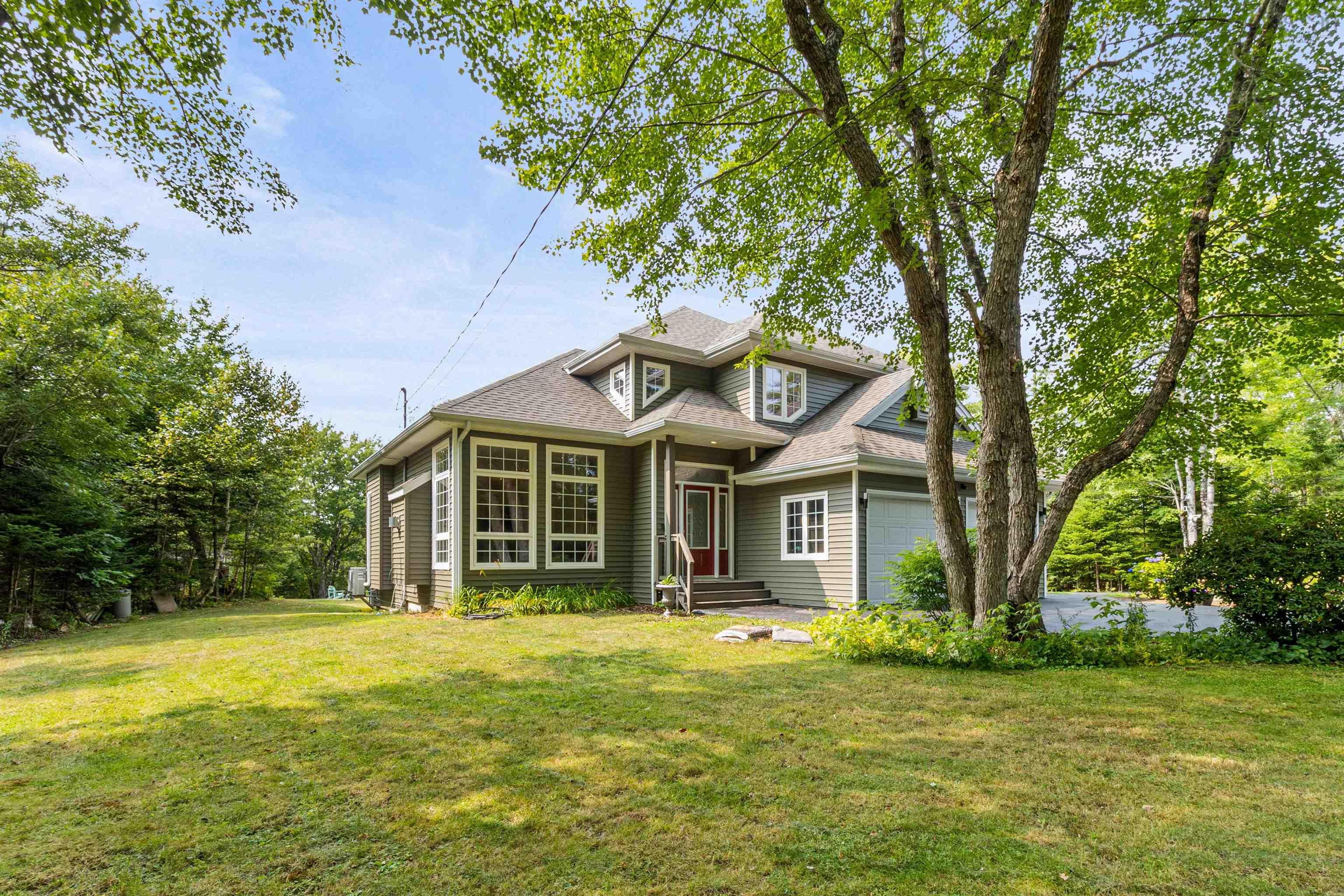 View of front of house featuring a garage, a front yard, and a shingled roof