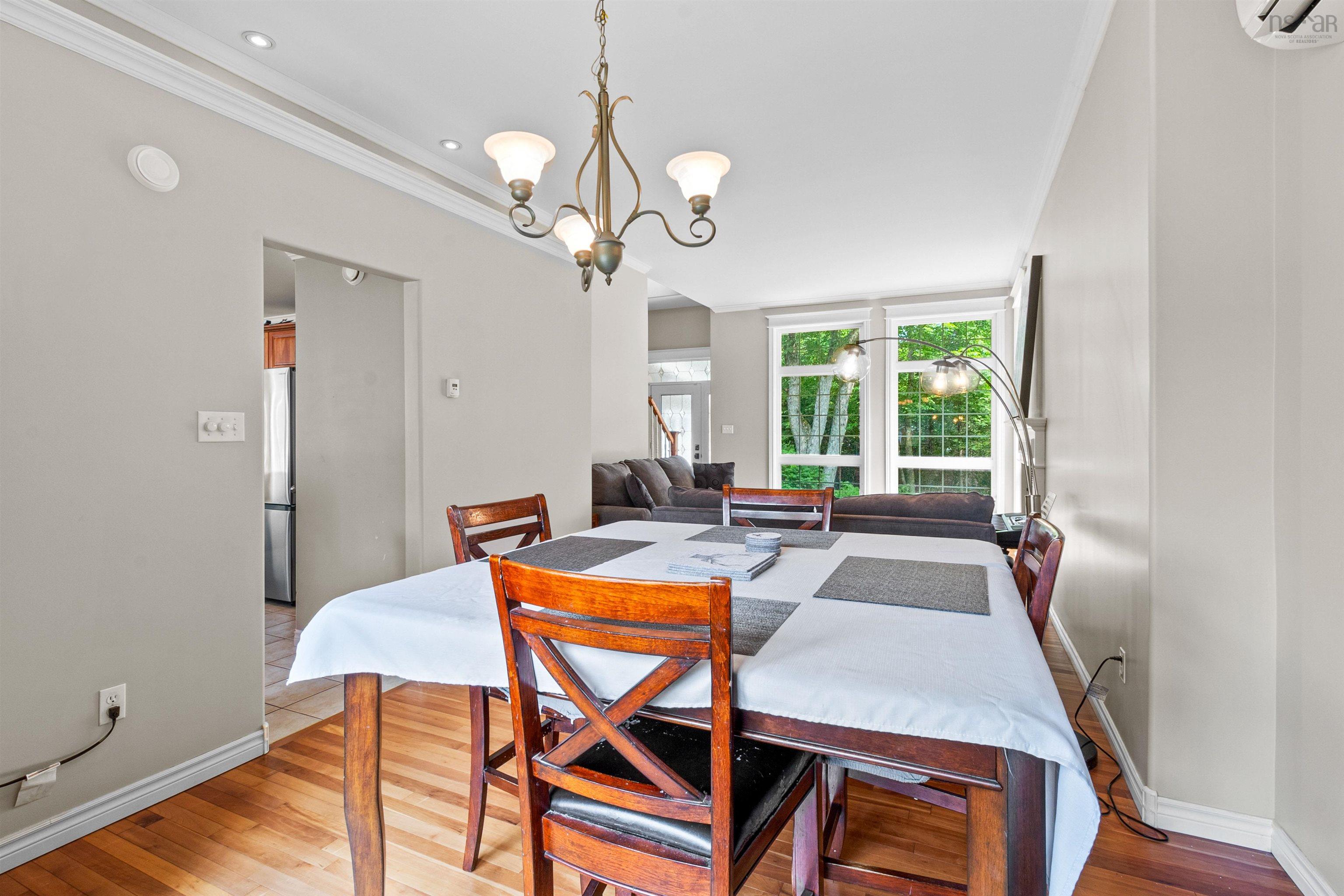 Dining area featuring light wood-style floors, a chandelier, ornamental molding, and an AC wall unit