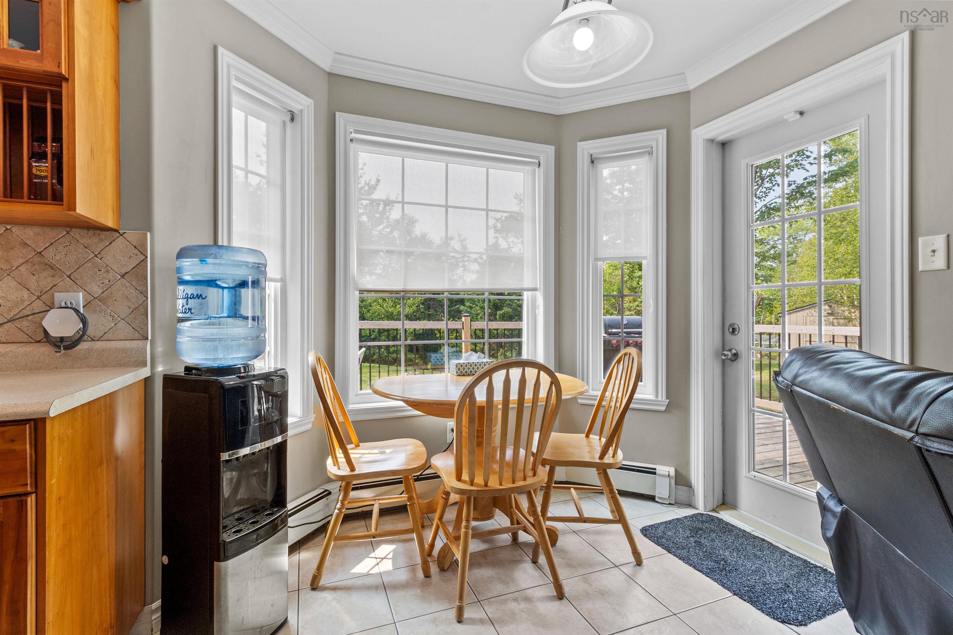 Dining room with light tile patterned floors, ornamental molding, and a baseboard heating unit