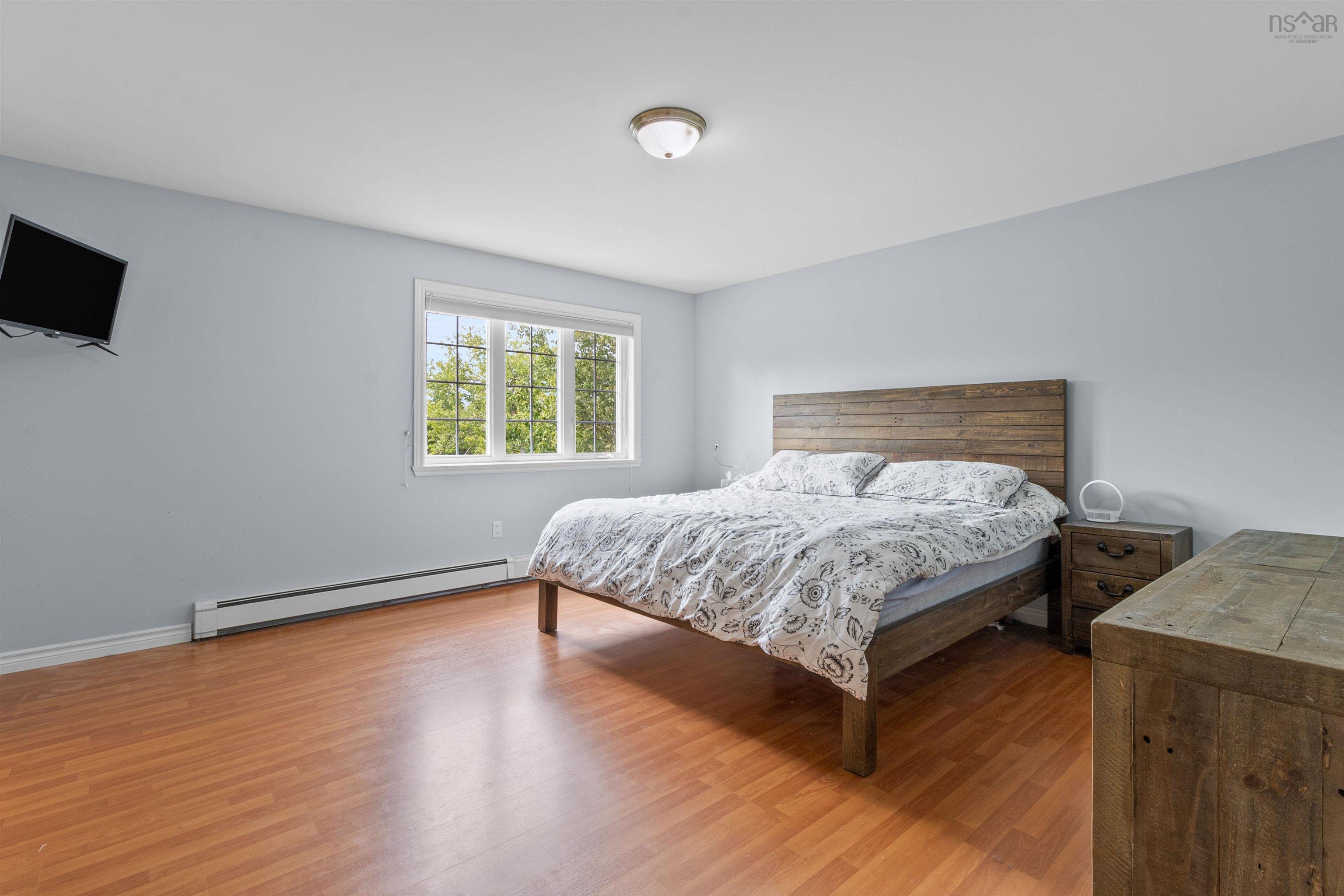 Bedroom with a baseboard radiator and light wood-style floors