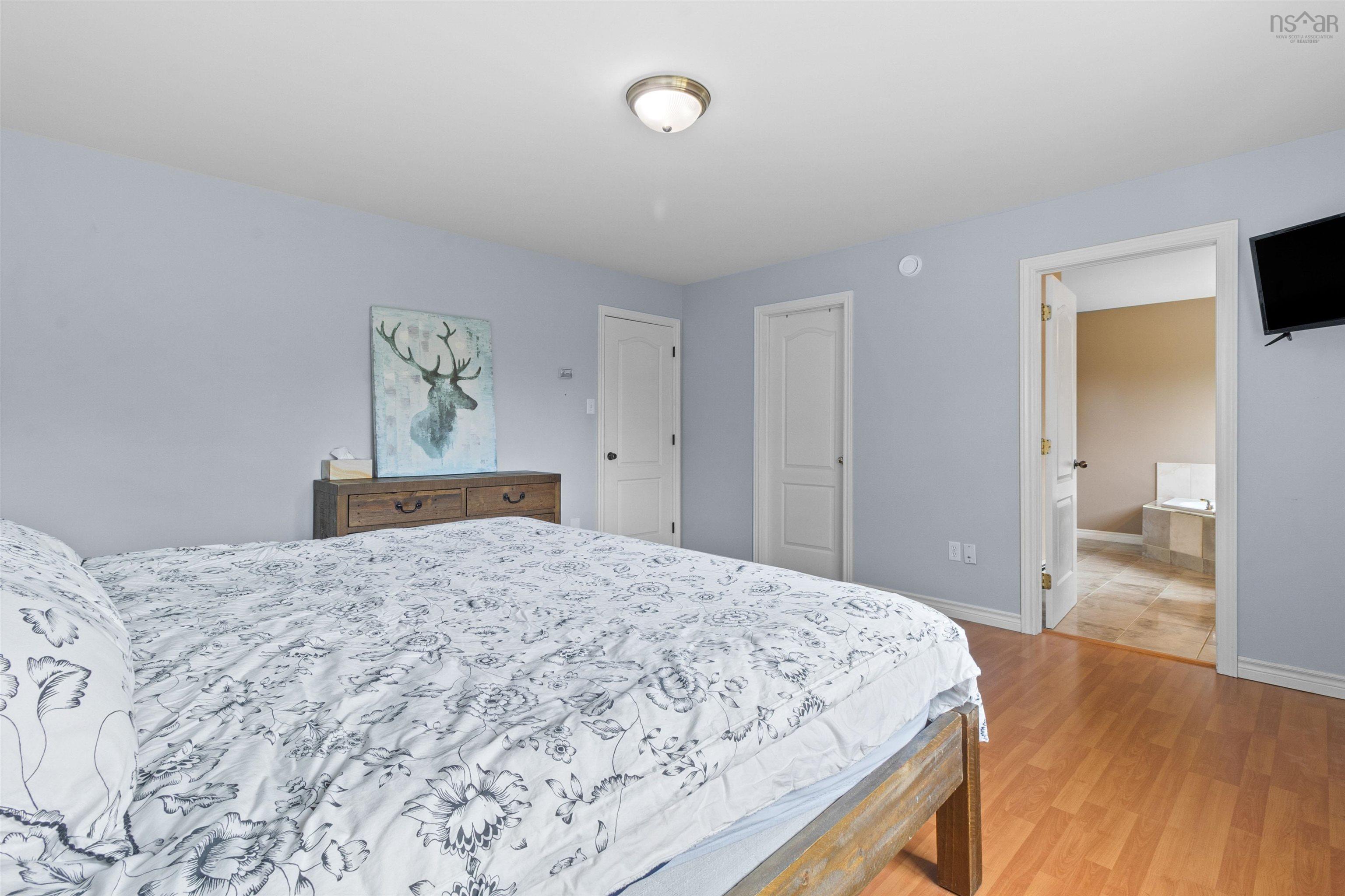 Bedroom with light wood-style floors and ensuite bathroom
