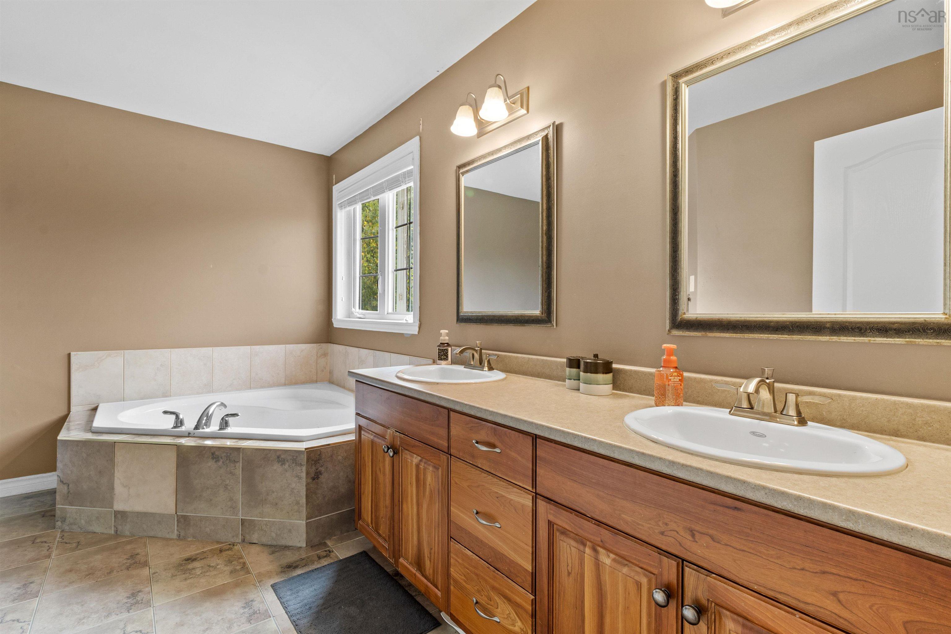 Full bath with a bath, double vanity, and light tile patterned floors