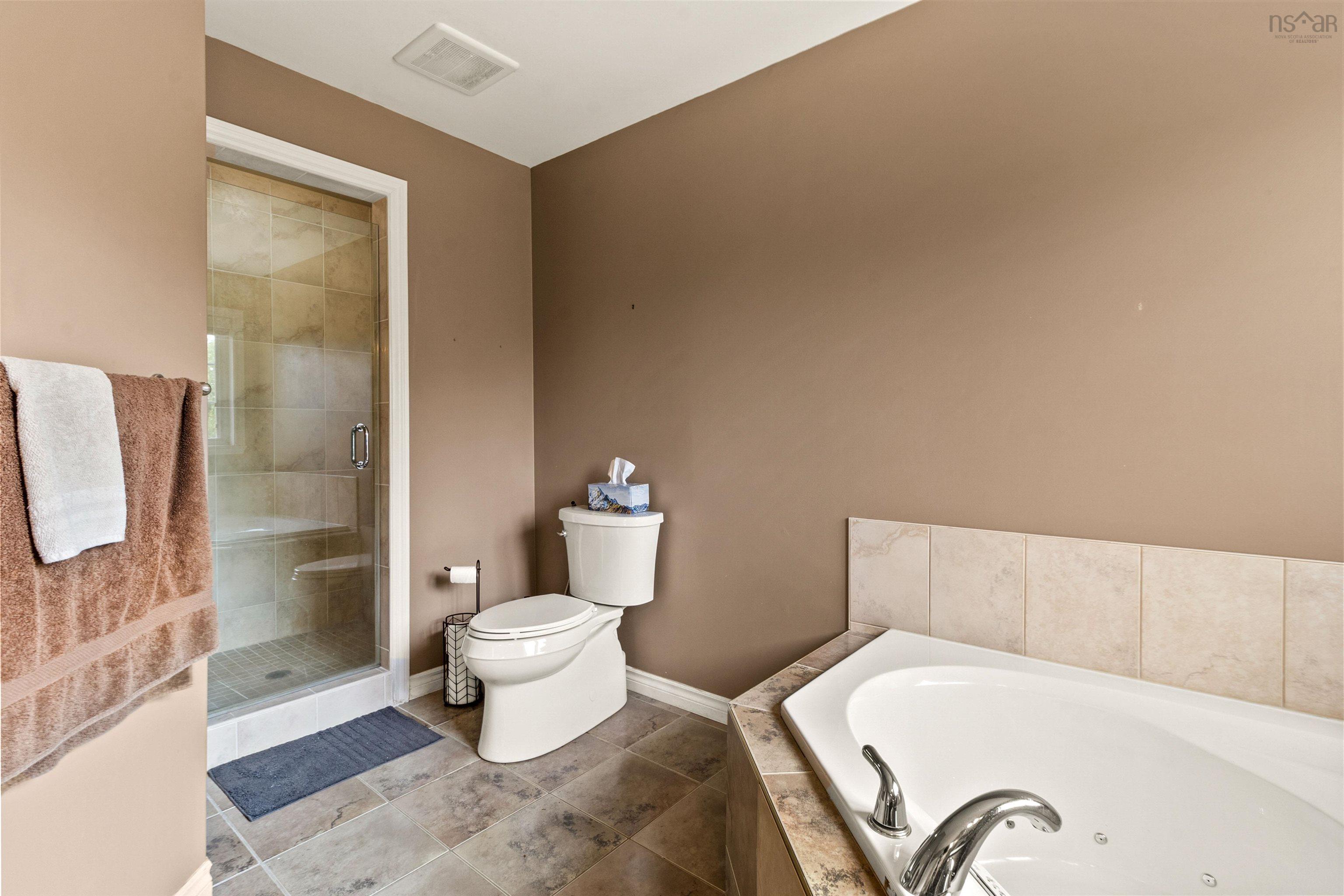 Bathroom featuring a tub with jets, a stall shower, and tile patterned floors
