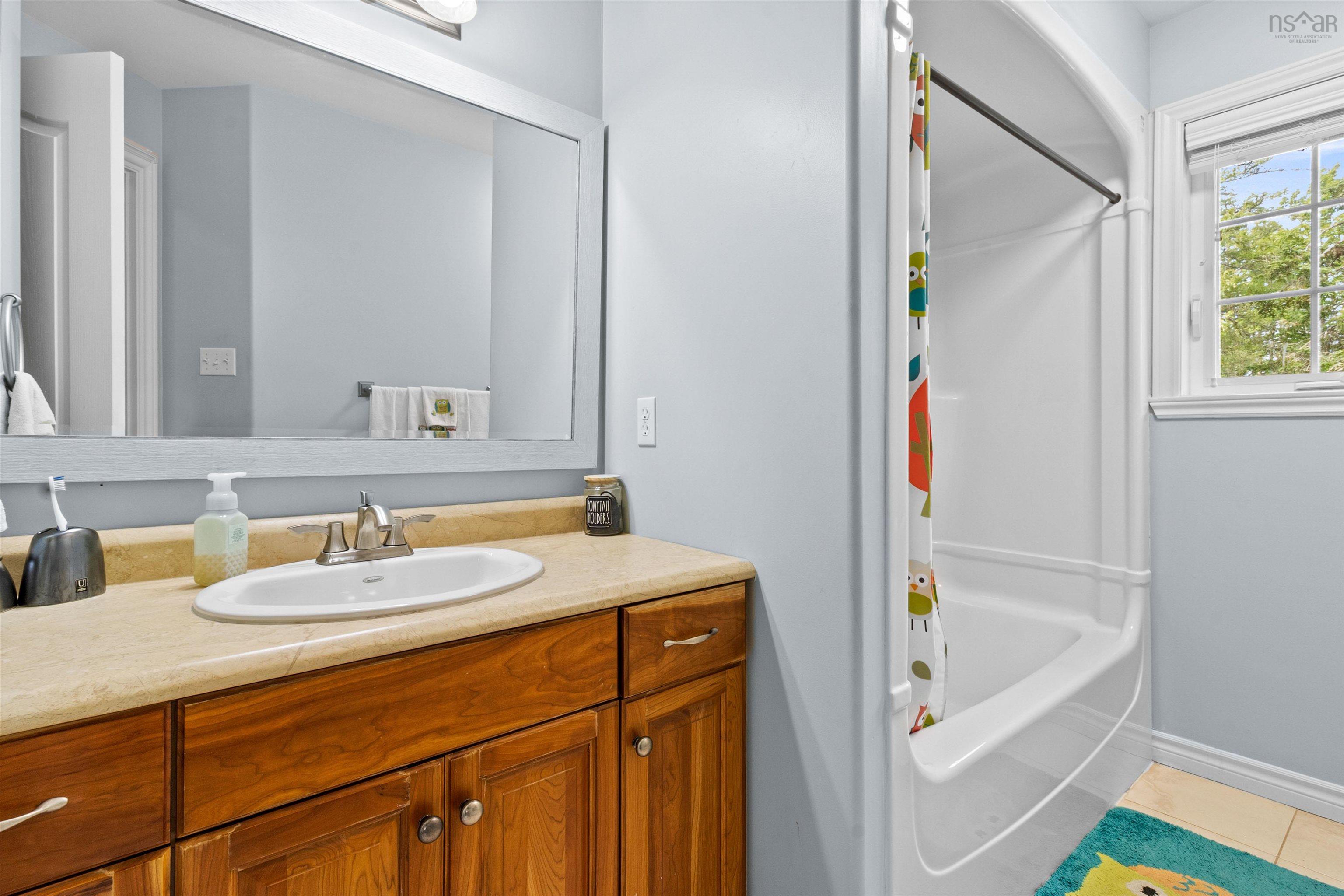 Full bathroom featuring shower / bathtub combination with curtain, vanity, and light tile patterned floors