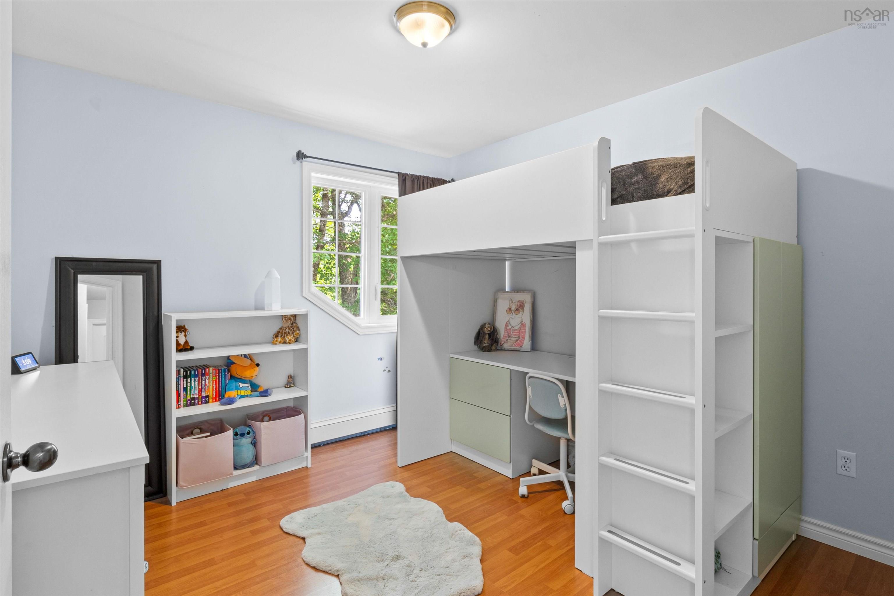 Bedroom featuring light wood finished floors and a desk