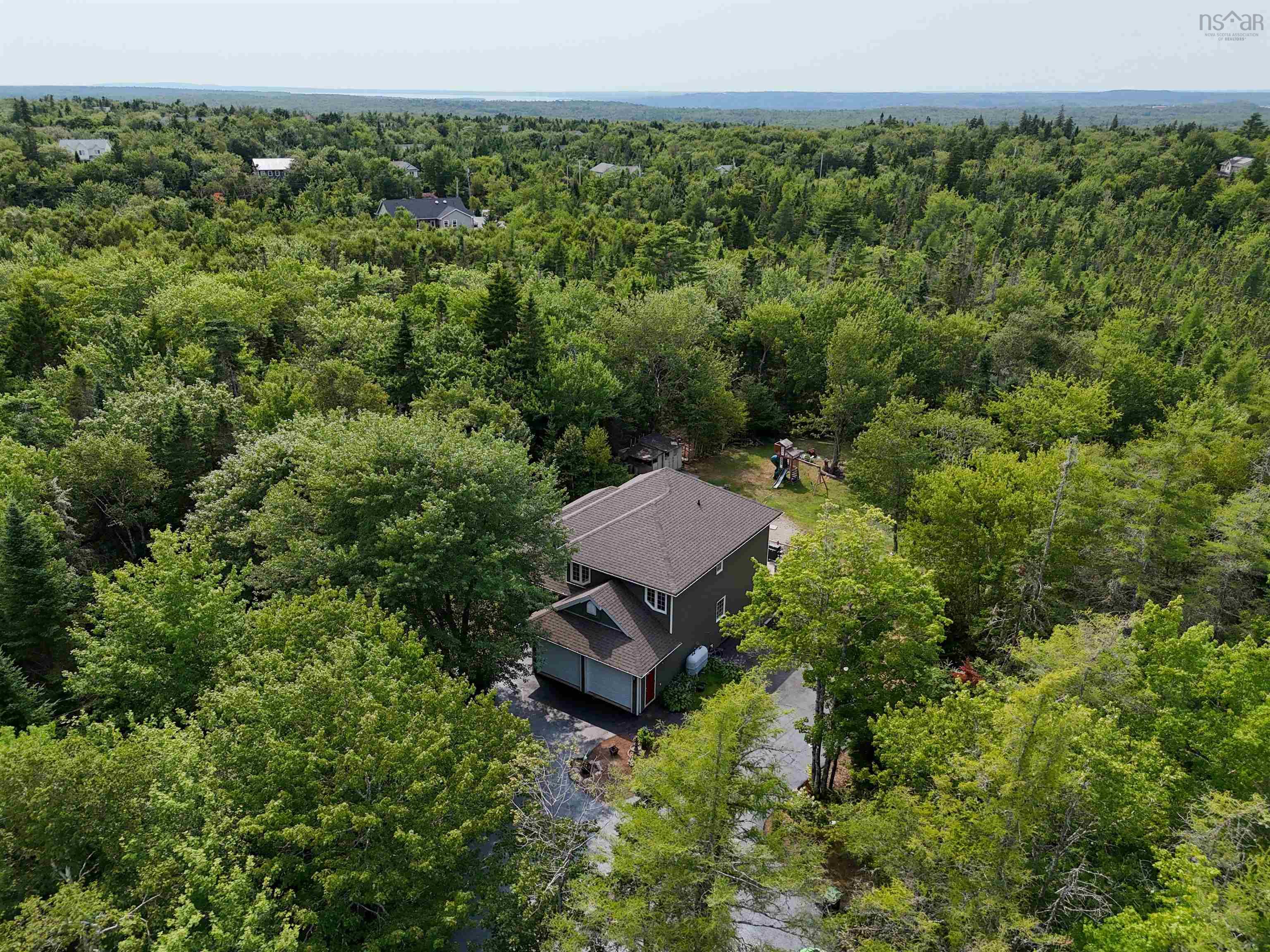 View of subject property with a heavily wooded area