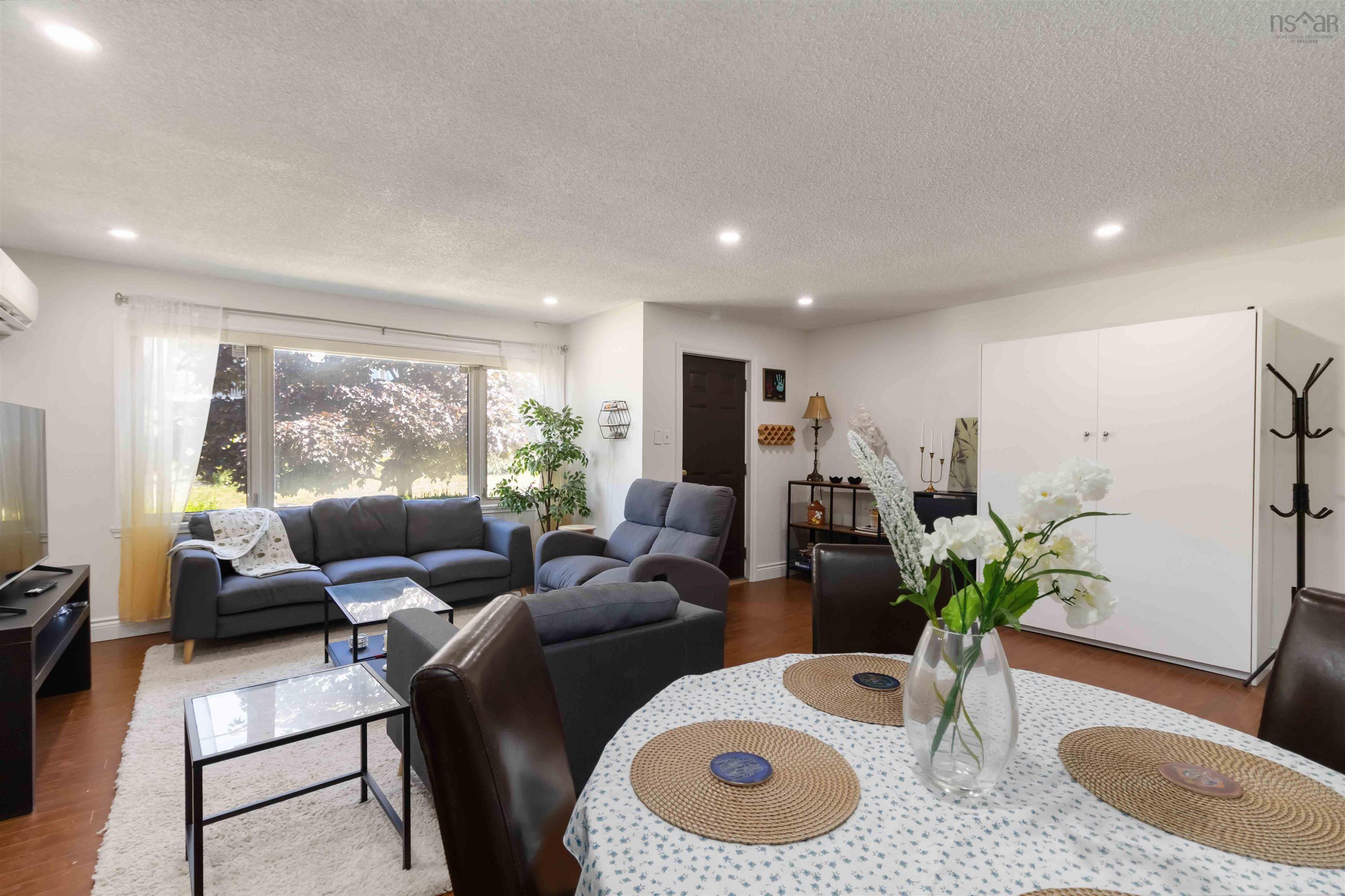Living area featuring wood finished floors, a textured ceiling, and recessed lighting