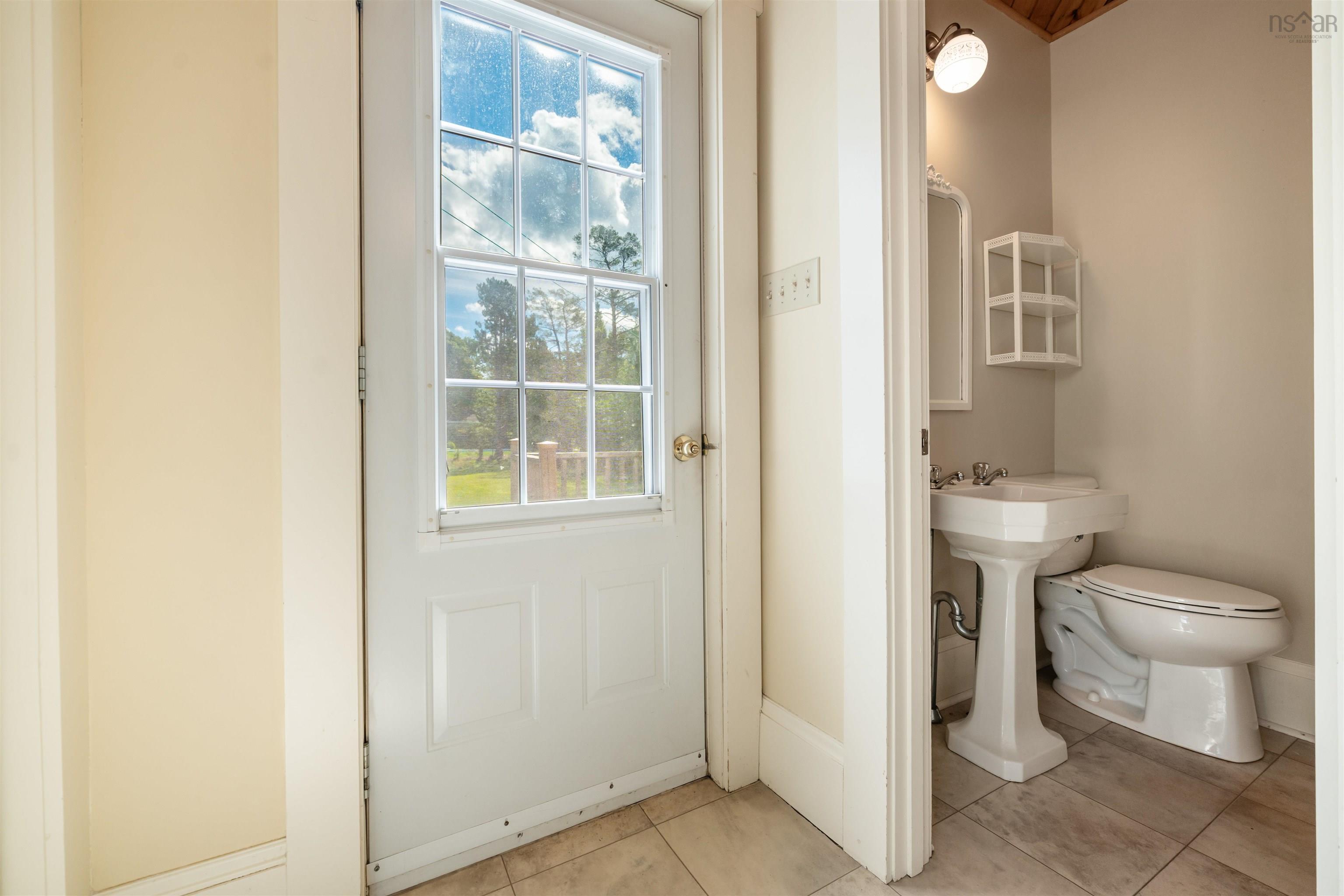 Doorway with tile patterned floors and baseboards