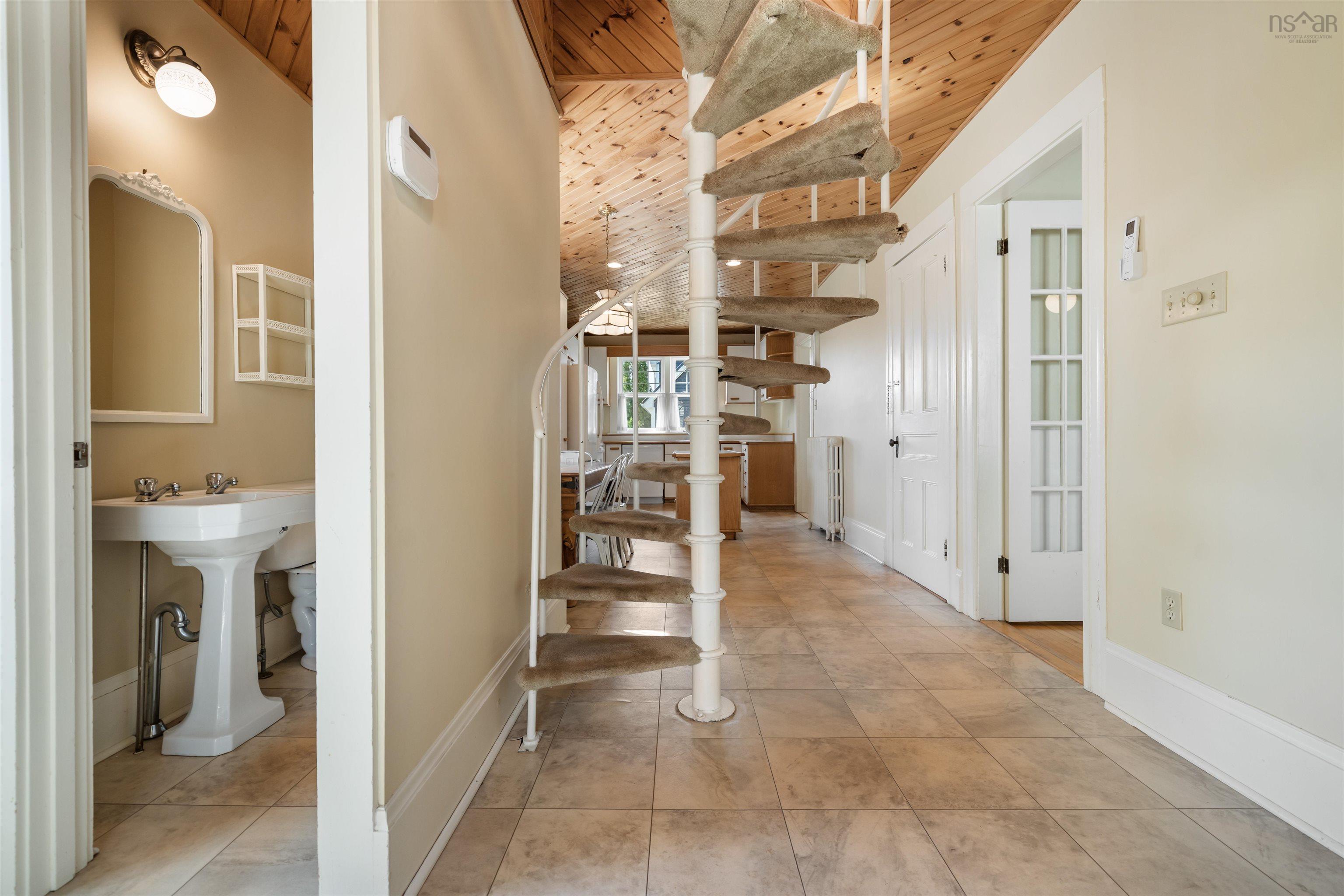 Stairs with radiator, tile patterned flooring, and wooden ceiling