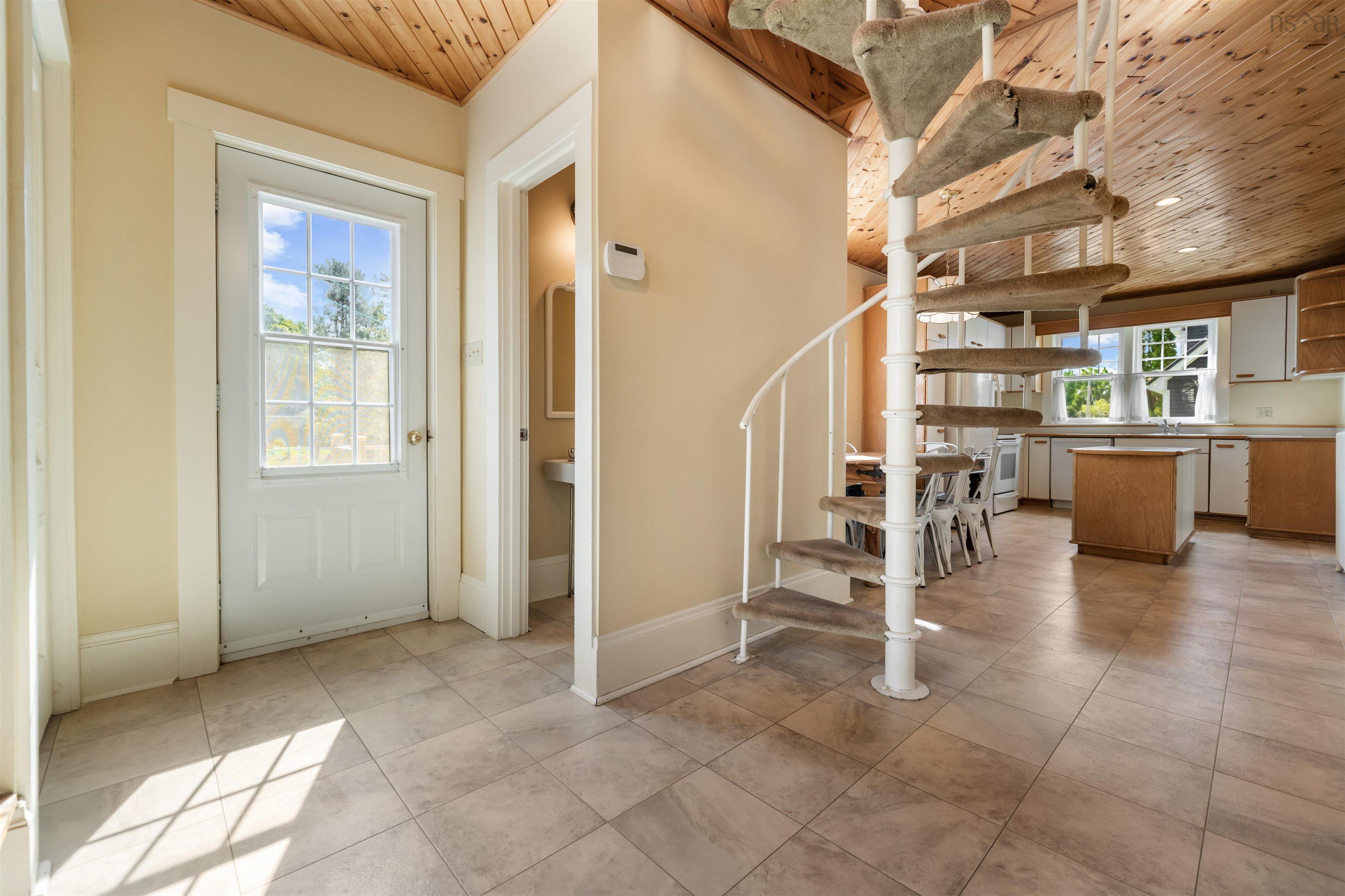 Foyer featuring wooden ceiling, stairs, and light tile patterned flooring