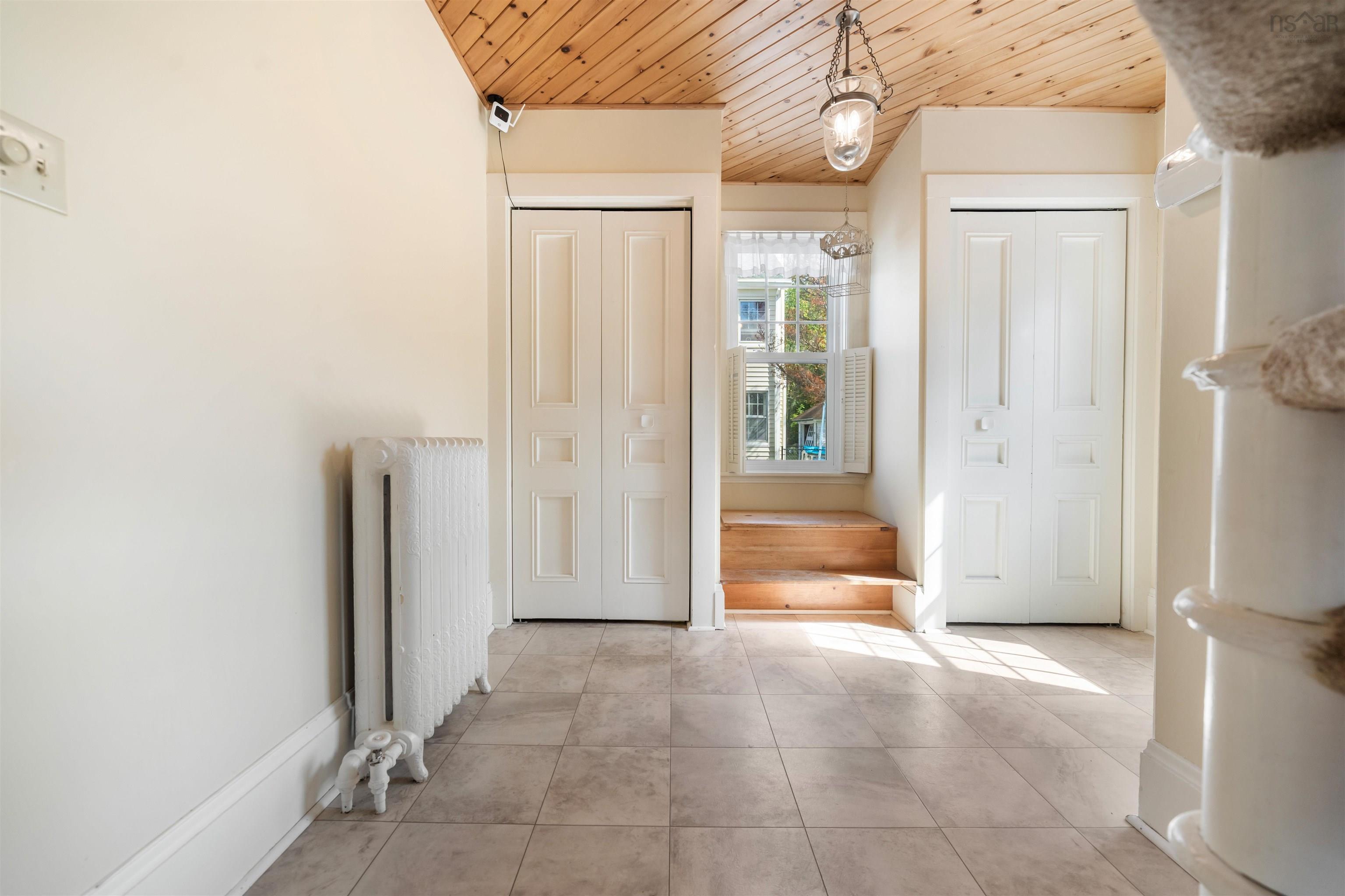 Entryway featuring radiator heating unit, wooden ceiling, and tile patterned flooring