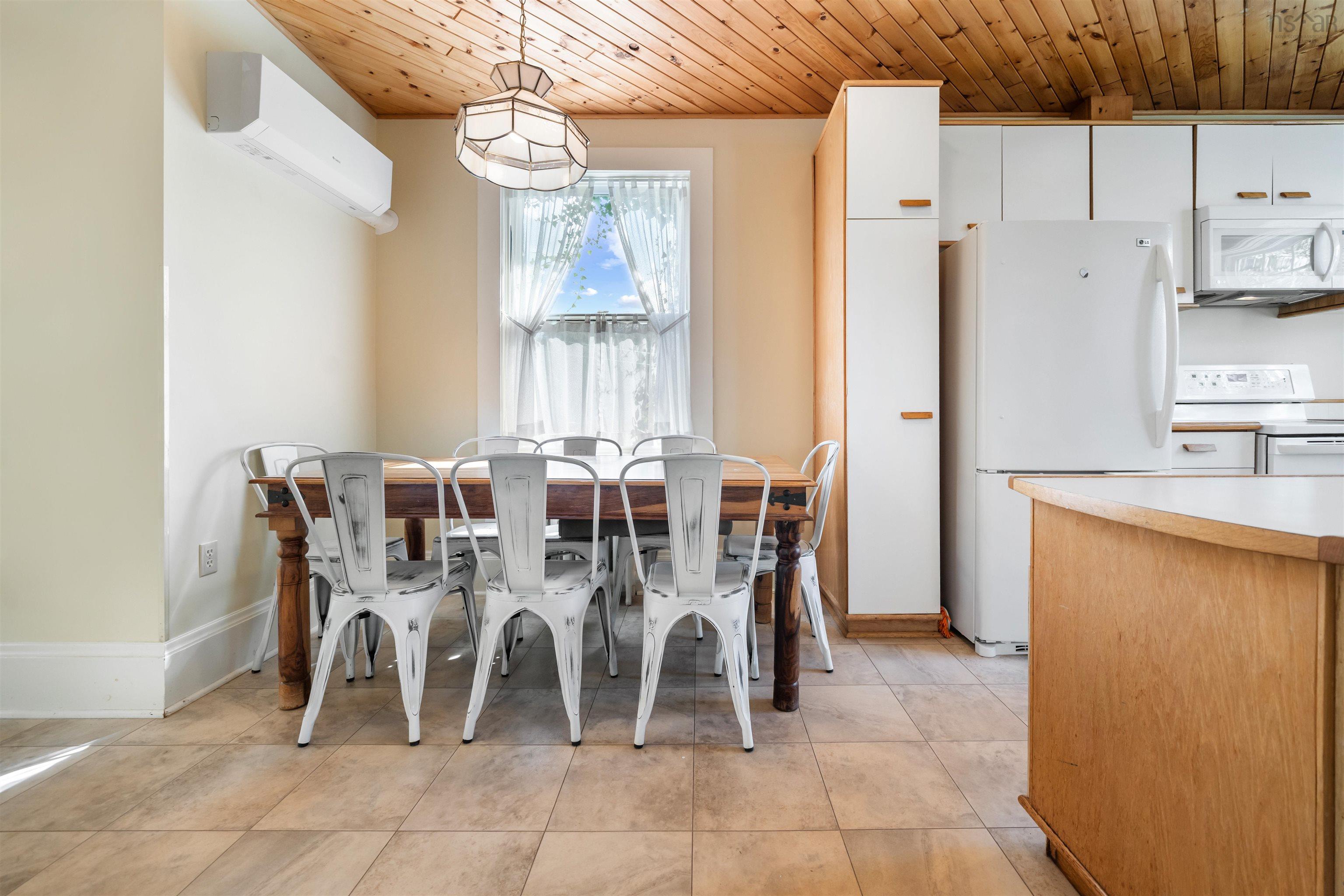 Dining area featuring wooden ceiling, a wall mounted air conditioner, and light tile patterned flooring