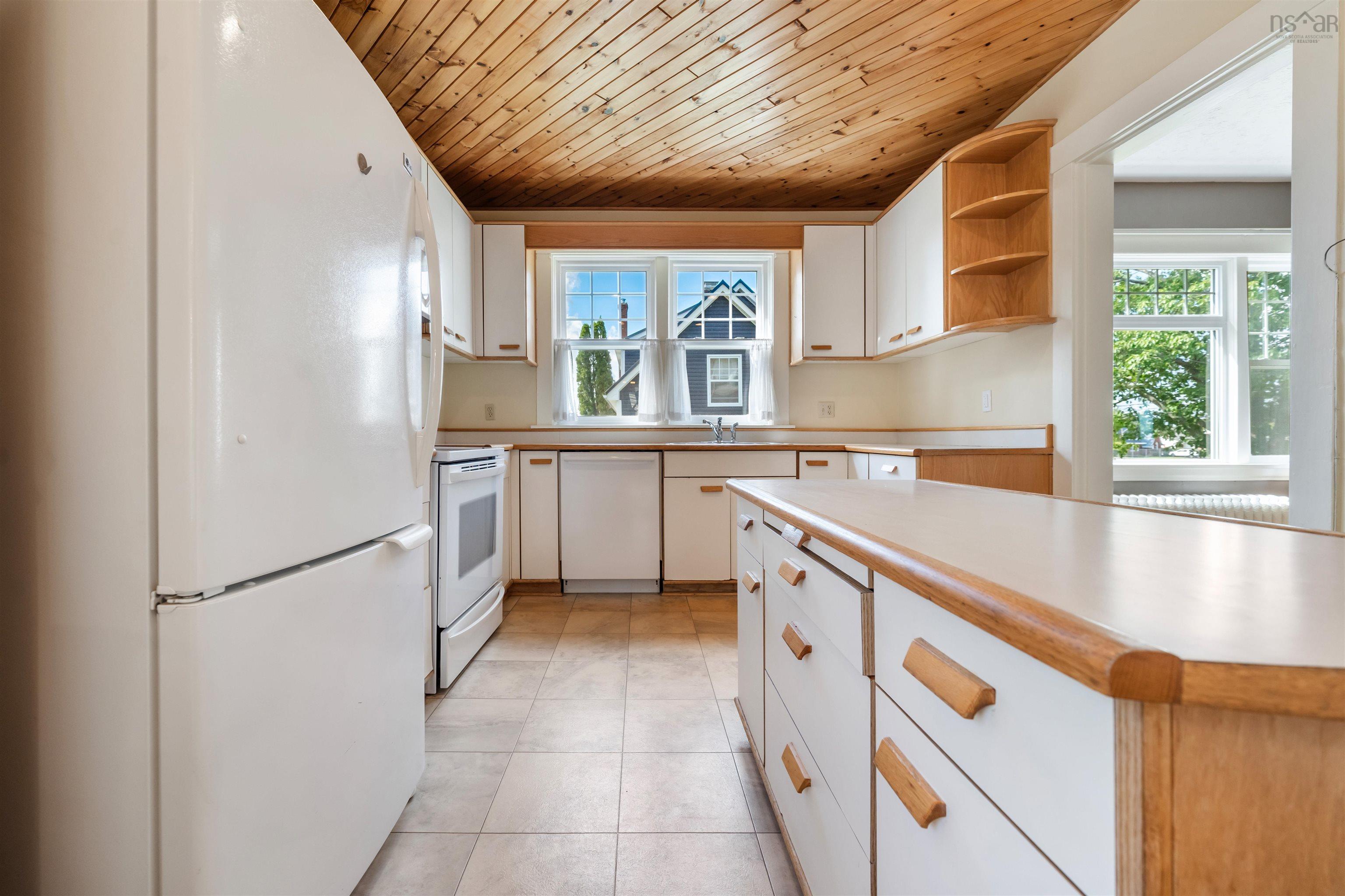 Kitchen with white appliances, white cabinetry, wood ceiling, light countertops, and open shelves
