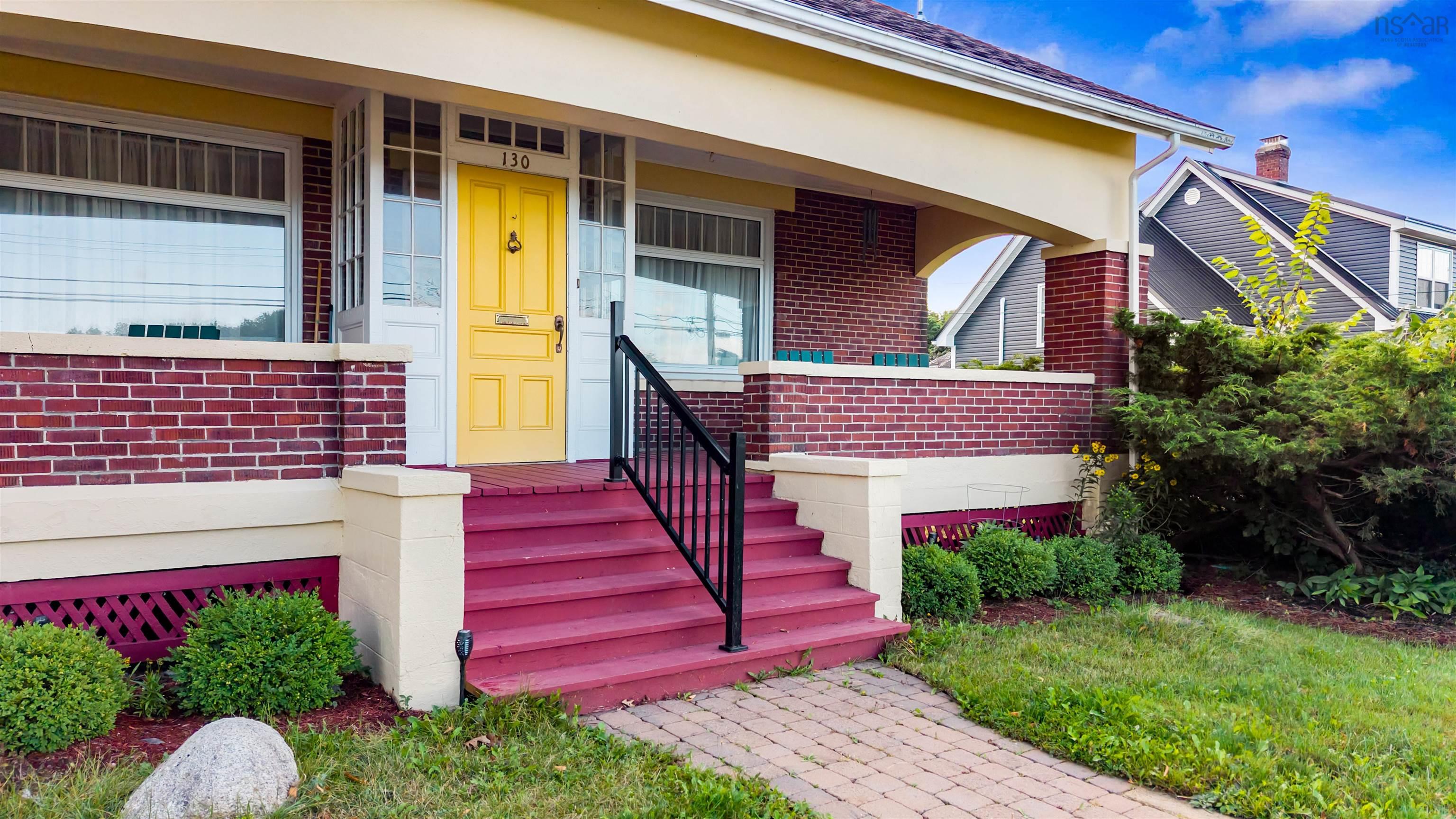 Entrance to property featuring brick siding and a porch