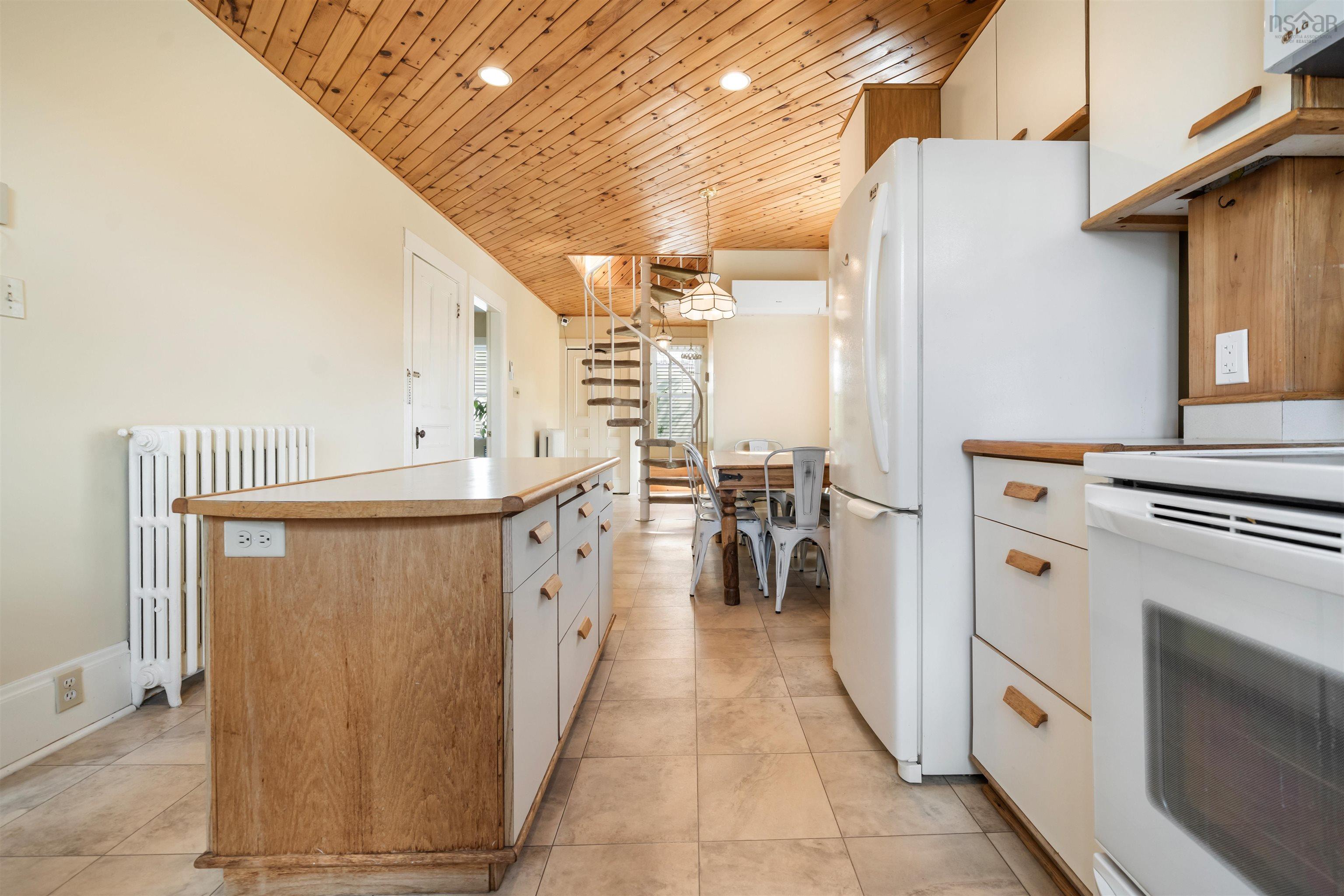 Kitchen featuring wood ceiling, radiator heating unit, white range with electric stovetop, recessed lighting, and decorative light fixtures