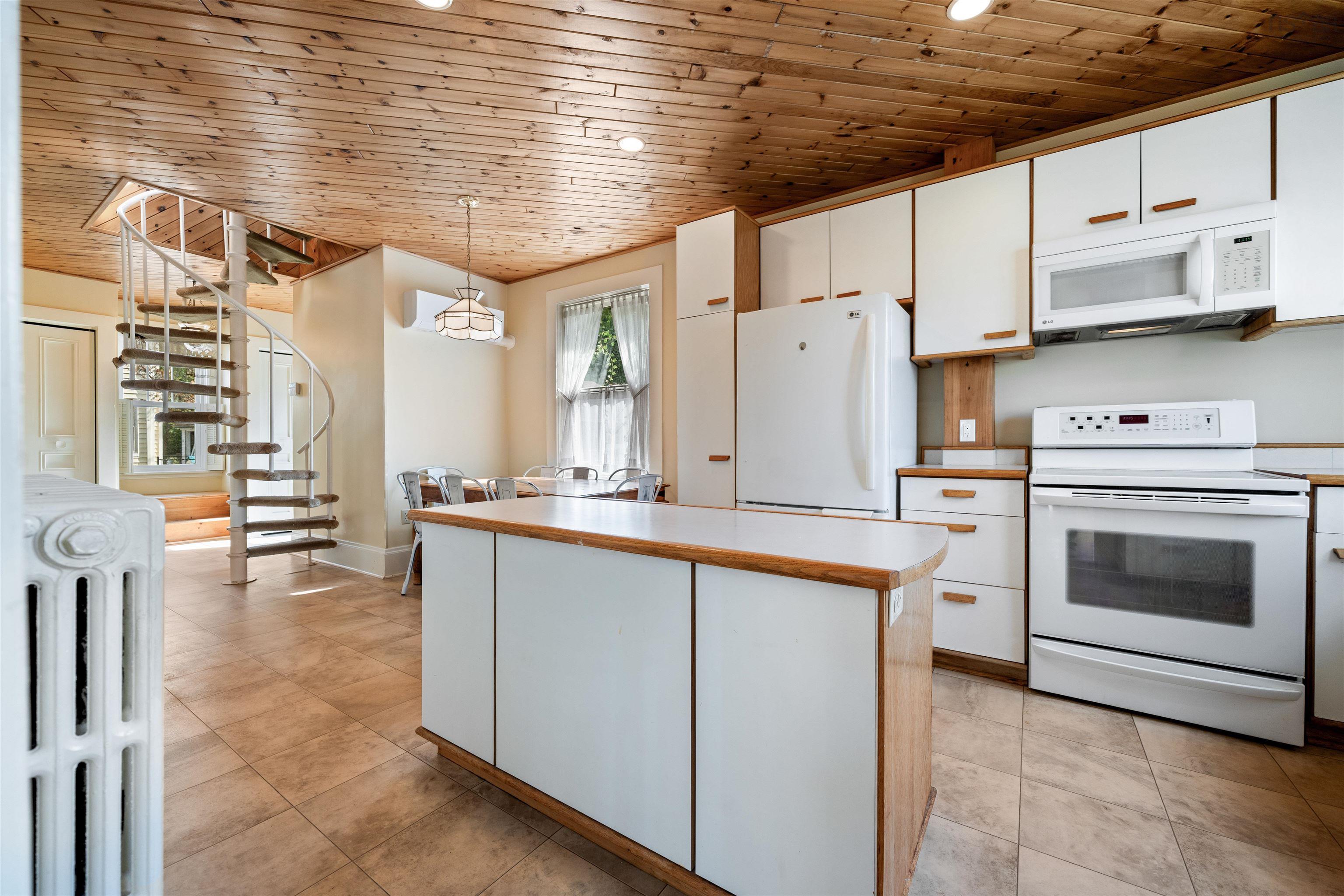 Kitchen with light countertops, wood ceiling, white appliances, white cabinetry, and pendant lighting