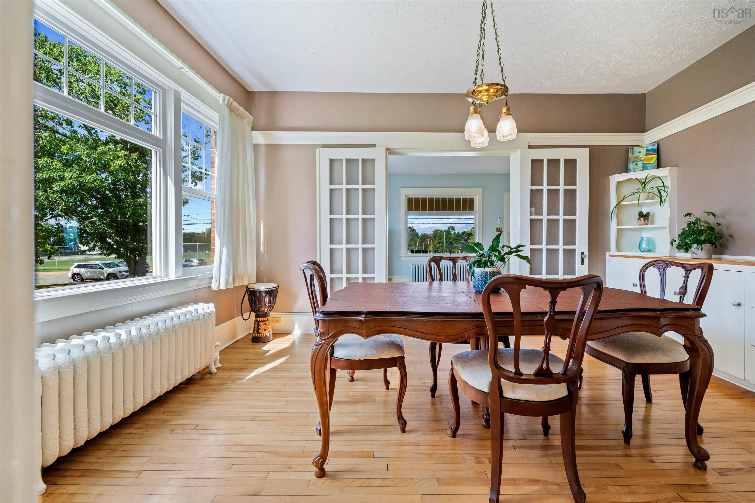 Dining area with radiator, hardwood / wood-style flooring, and french doors