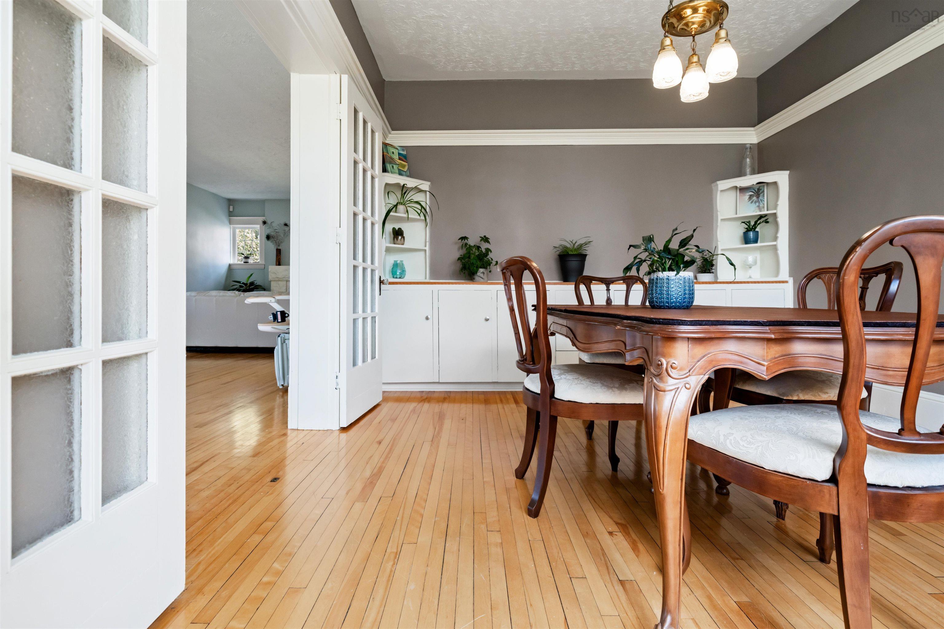 Dining area with light wood-style flooring, a textured ceiling, and a chandelier