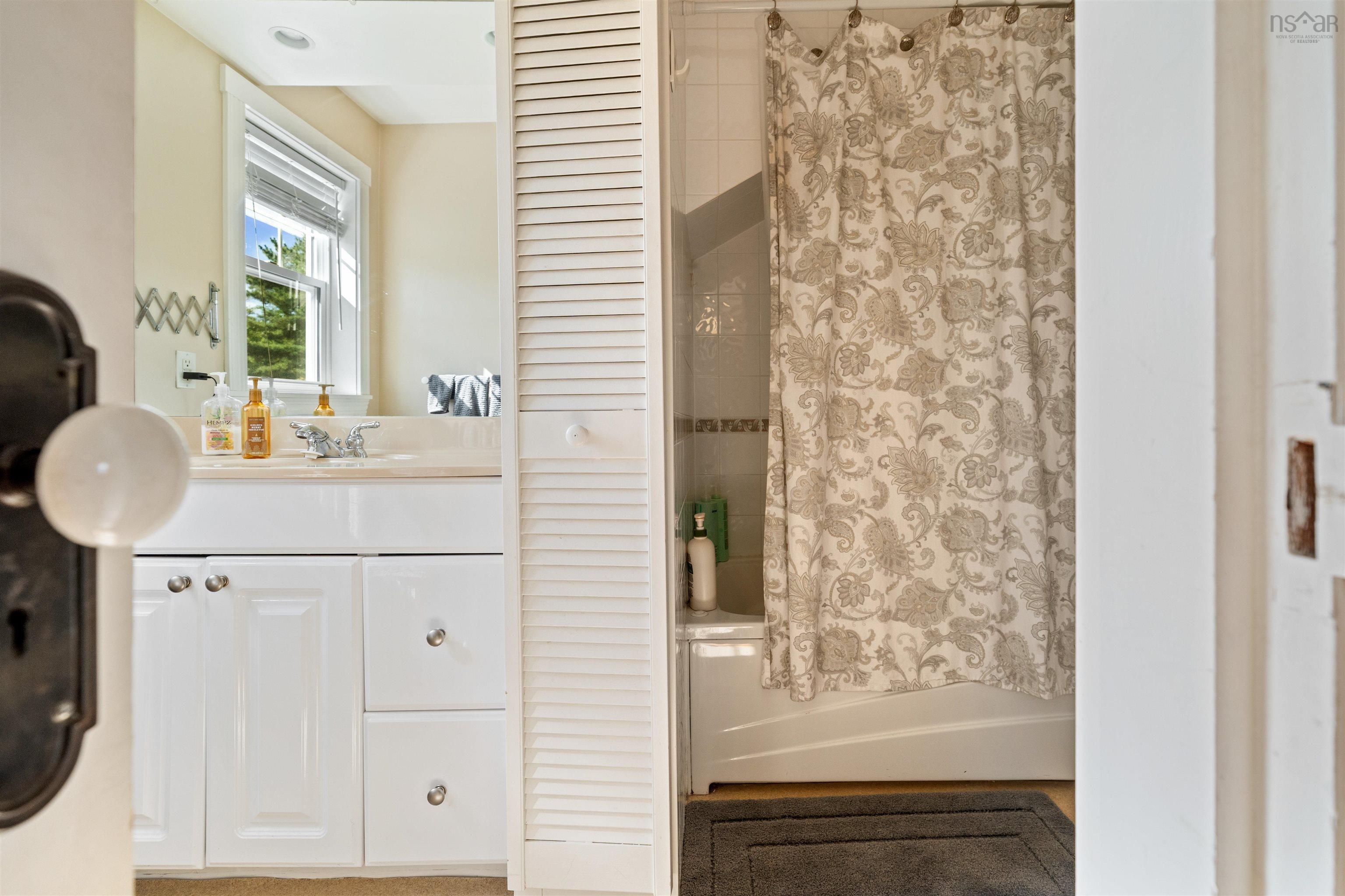 Bathroom featuring shower / tub combo, vanity, and a closet
