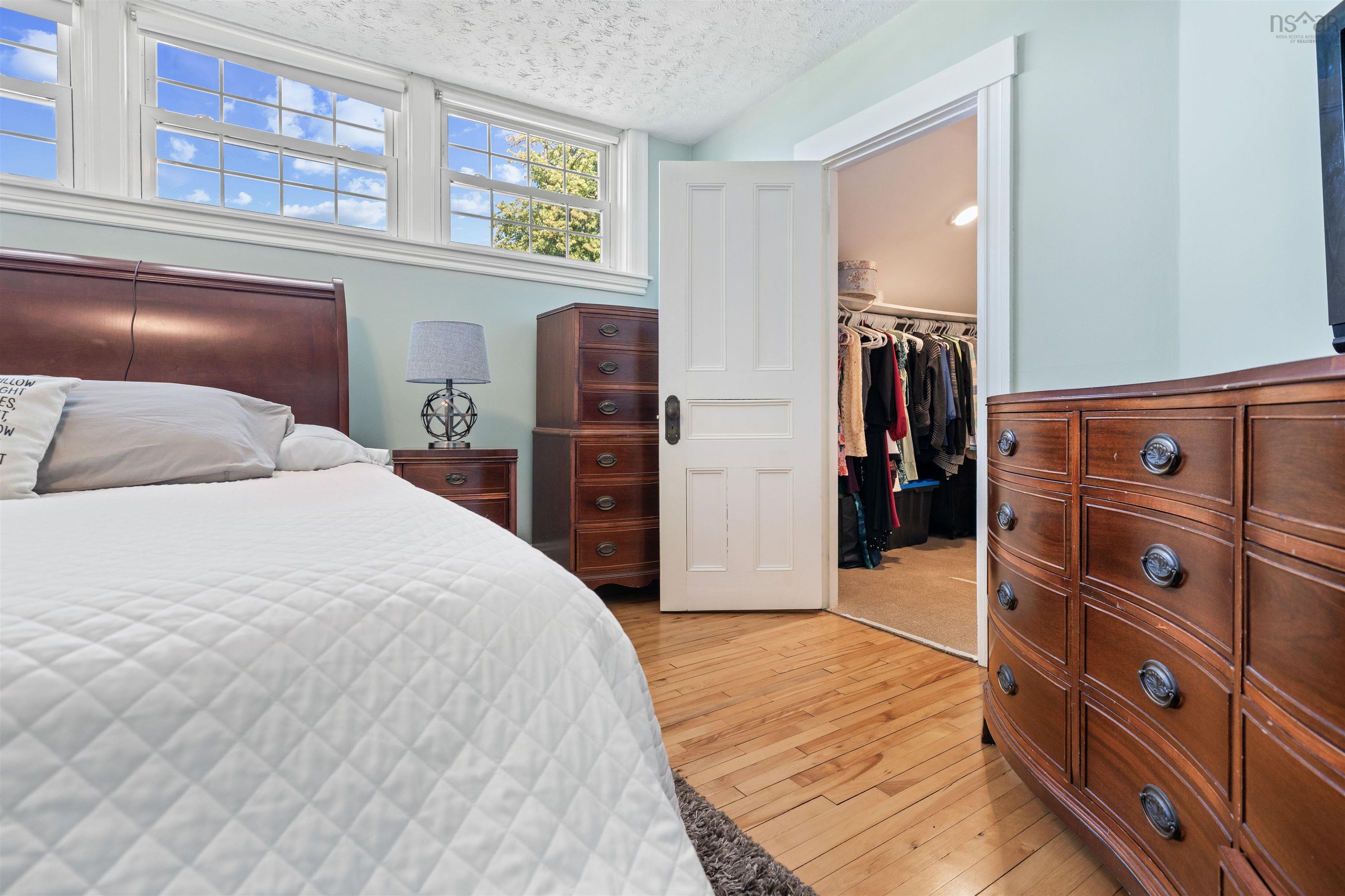 Bedroom featuring a textured ceiling, light wood finished floors, and a spacious closet