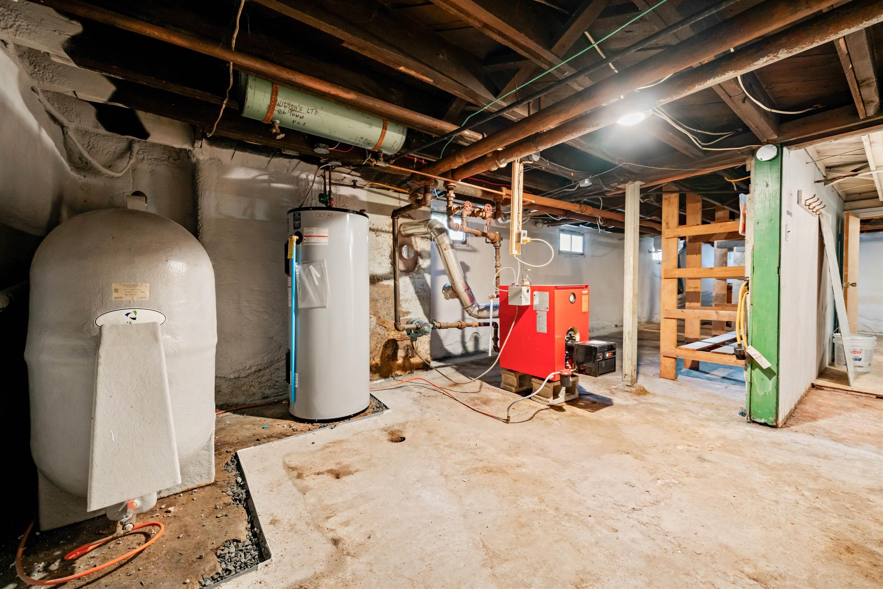 Basement with water heater, a heating unit, and a water pressure tank