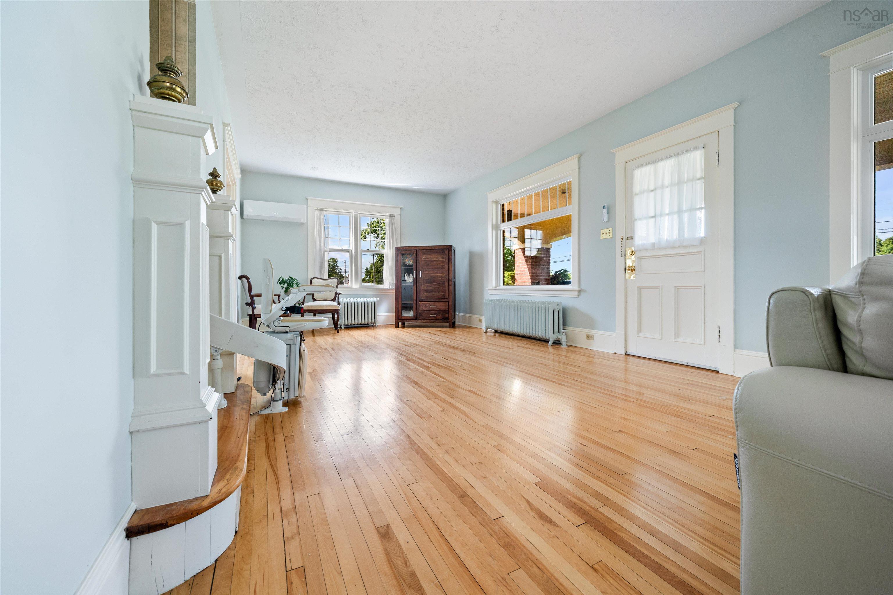 Entrance foyer featuring radiator, light wood finished floors, an AC wall unit, and a textured ceiling
