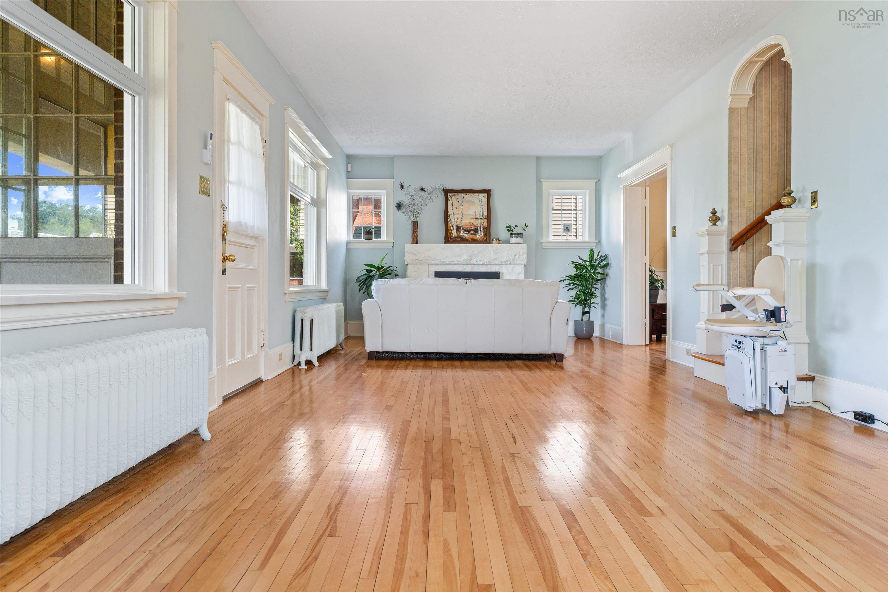 Living area with light wood-type flooring and radiator heating unit