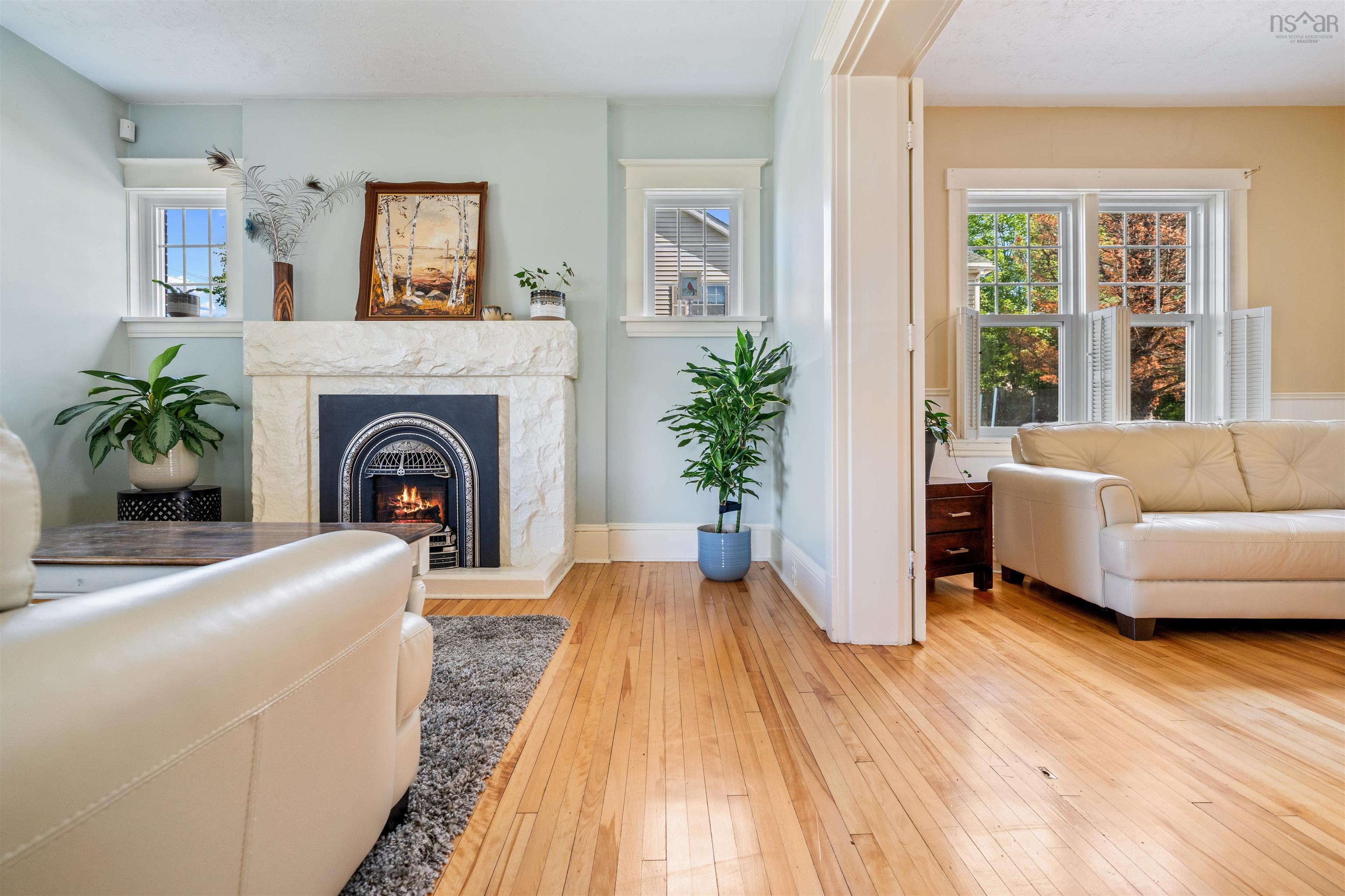 Living room with light wood finished floors and a high end fireplace