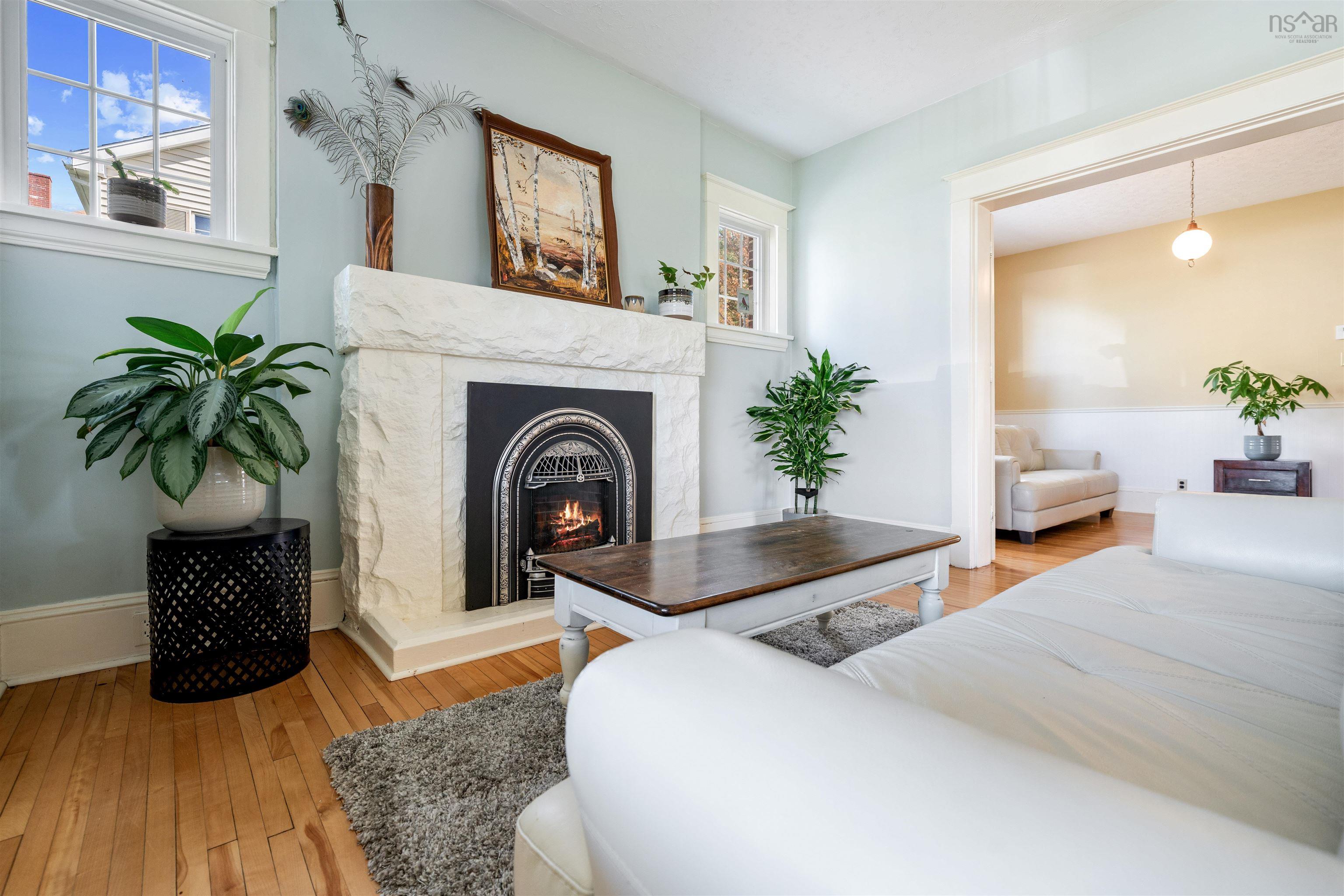 Living area featuring light wood-style floors and a high end fireplace
