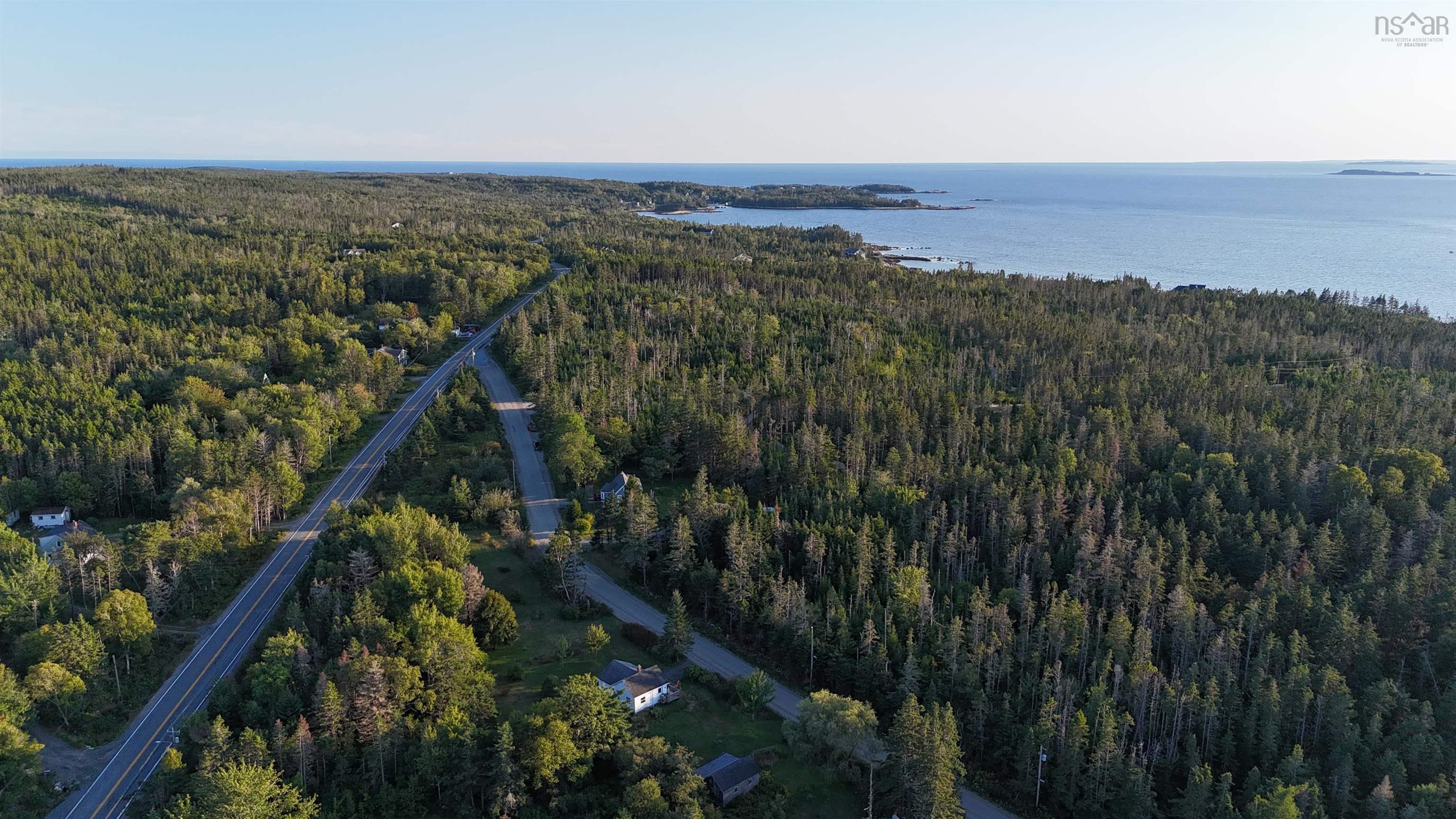 Aerial overview of property's location with a heavily wooded area