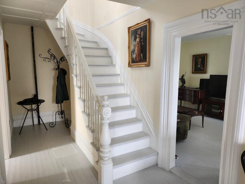 Staircase with hardwood / wood-style flooring and baseboards