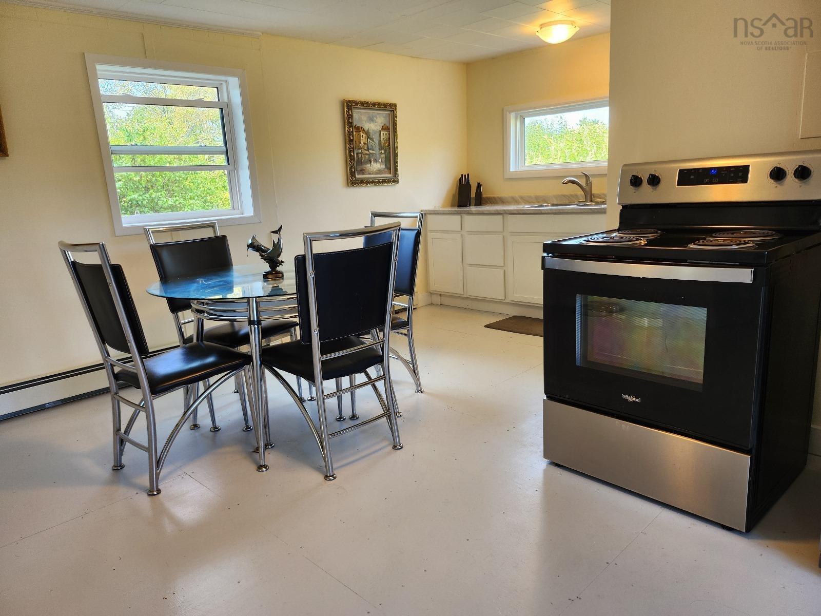 Kitchen with stainless steel electric range oven, white cabinetry, and light countertops