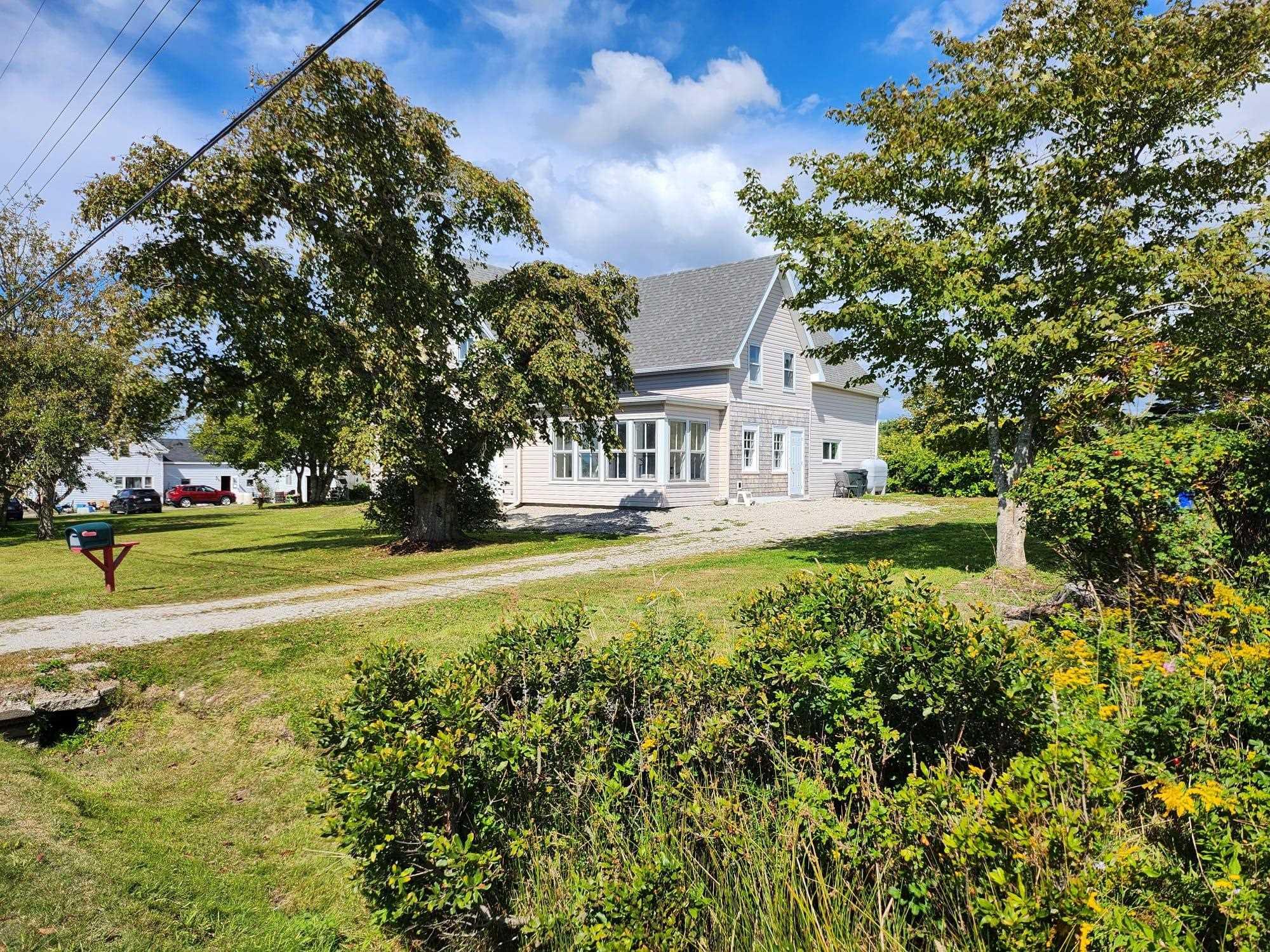 View of front of house featuring a front lawn and roof with shingles