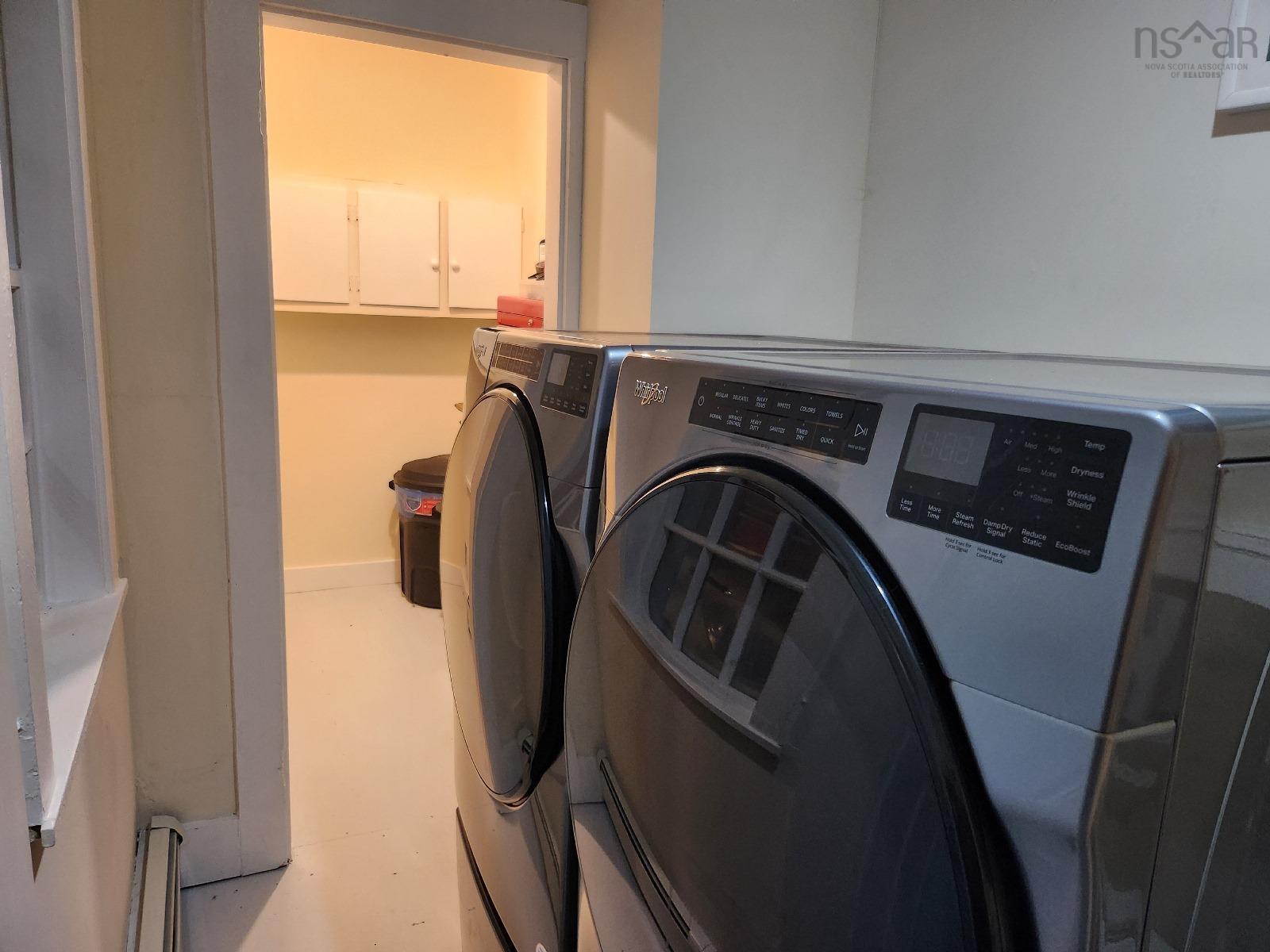 Washroom with separate washer and dryer and baseboards