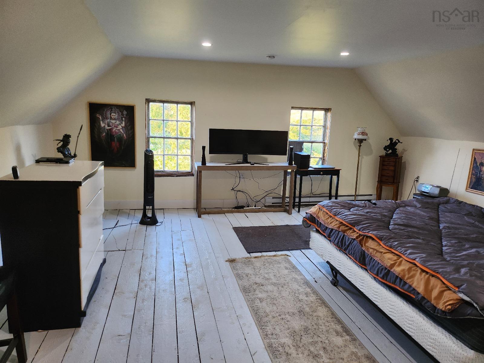 Bedroom with vaulted ceiling, light wood-type flooring, recessed lighting, and an office area