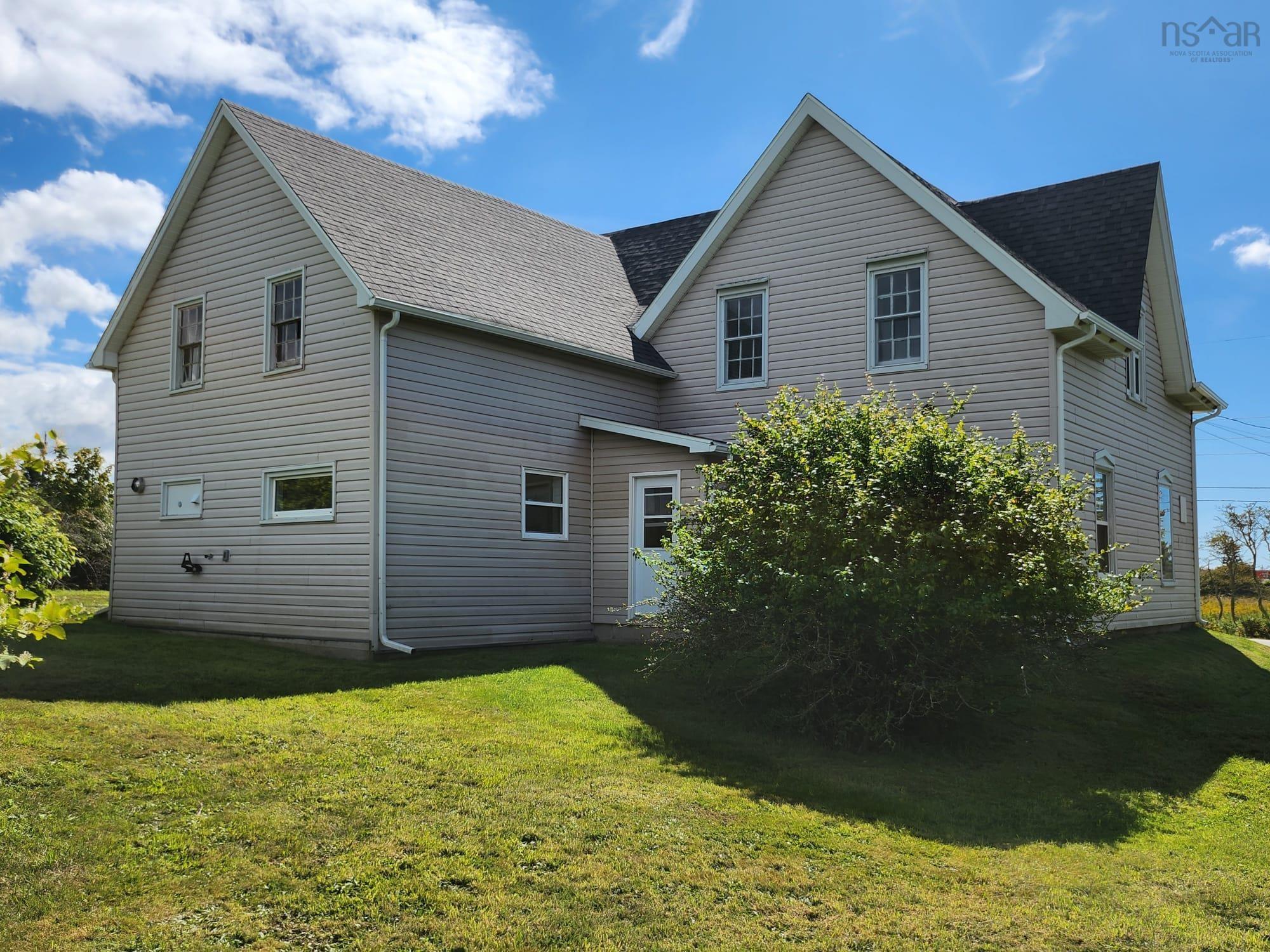 Rear view of property with a yard and roof with shingles