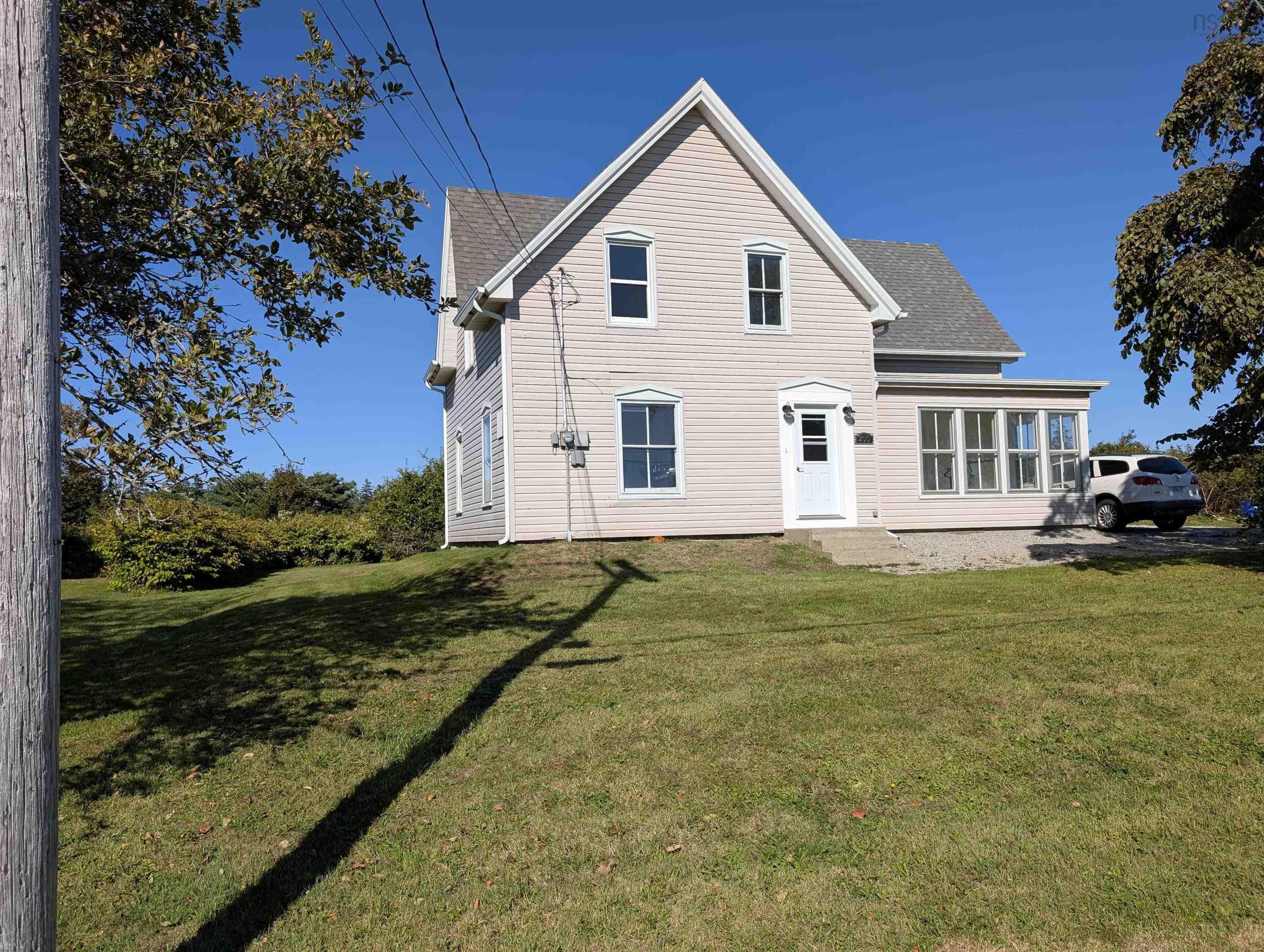 Rear view of property featuring a lawn and a shingled roof