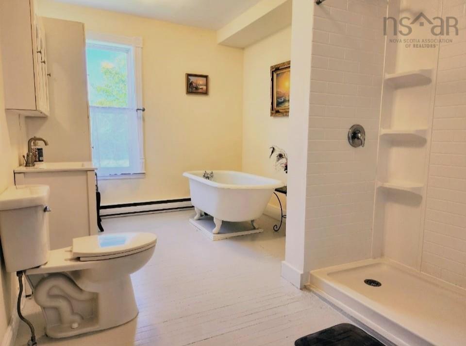 Bathroom with a soaking tub, a stall shower, and a baseboard radiator