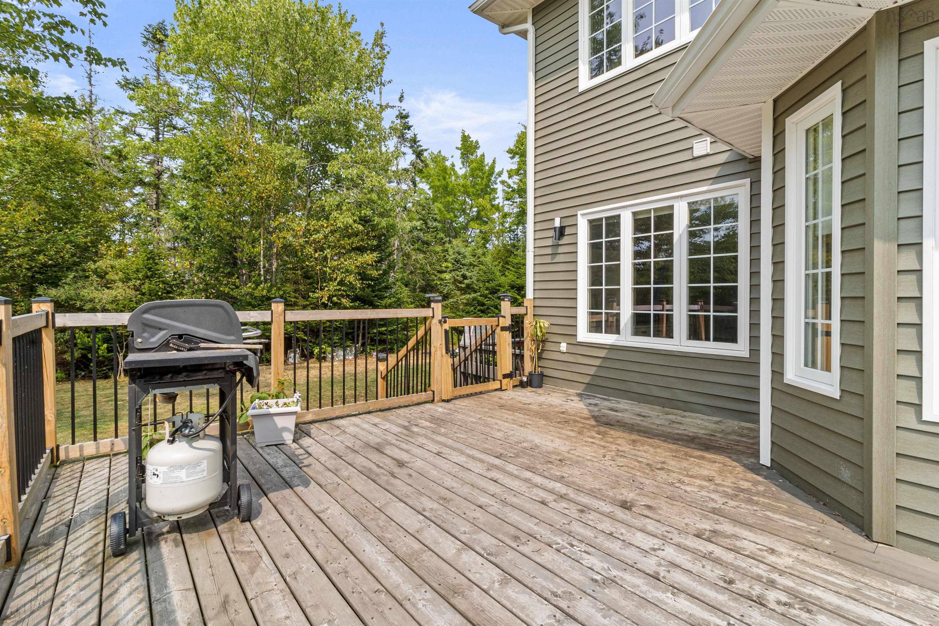 Deck featuring view of scattered trees and a grill